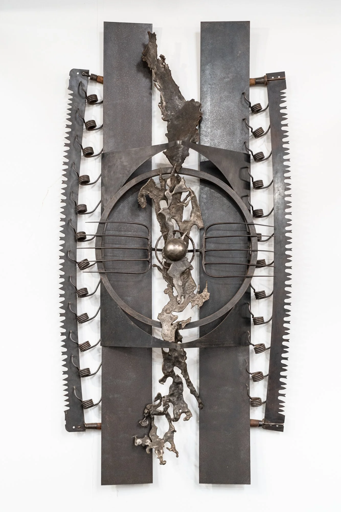Devices of Penetration - The work draws inspiration from the diverse array of agricultural tools essential for cultivating the land and processing its yields. Pitch forks, vintage saw blades, welded steel, cast stainless. 6’4” x 3’3” x12”. 1993.