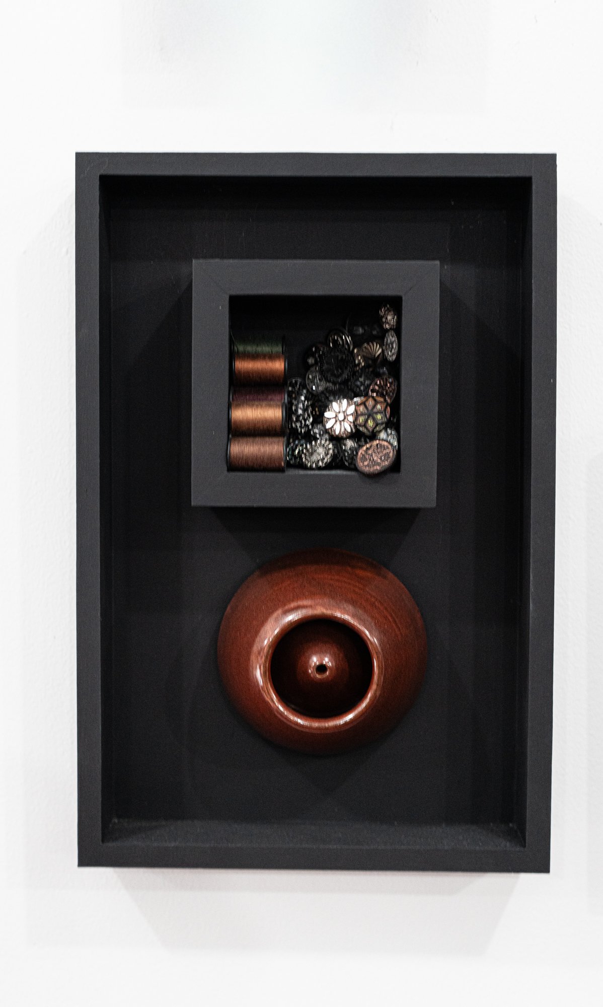 Secrets - Inspired by vintage buttons and what they may have held together. Thrown clay, wood, spools of thread, vintage buttons. 12” x 6” x 2.5”. 2019