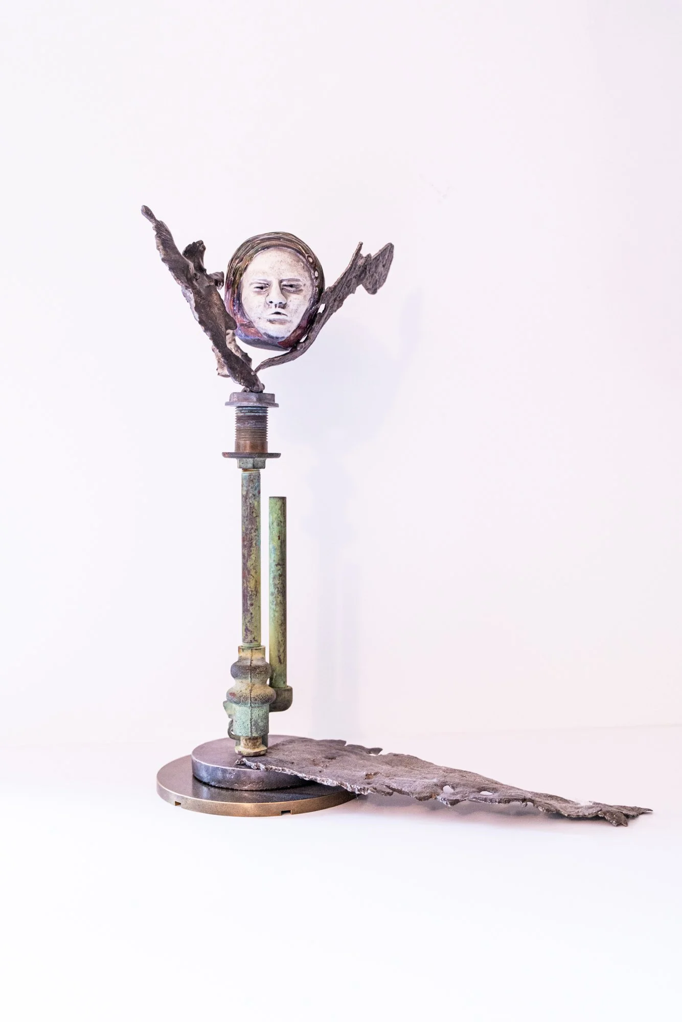 Spirit of Flint - Inspired by the disastrous water problem in Flint Michigan. Welded steel, cast stainless steel, copper pipes, raku clay head brass base. 15.25” x 9” x 12.5”. 2021 