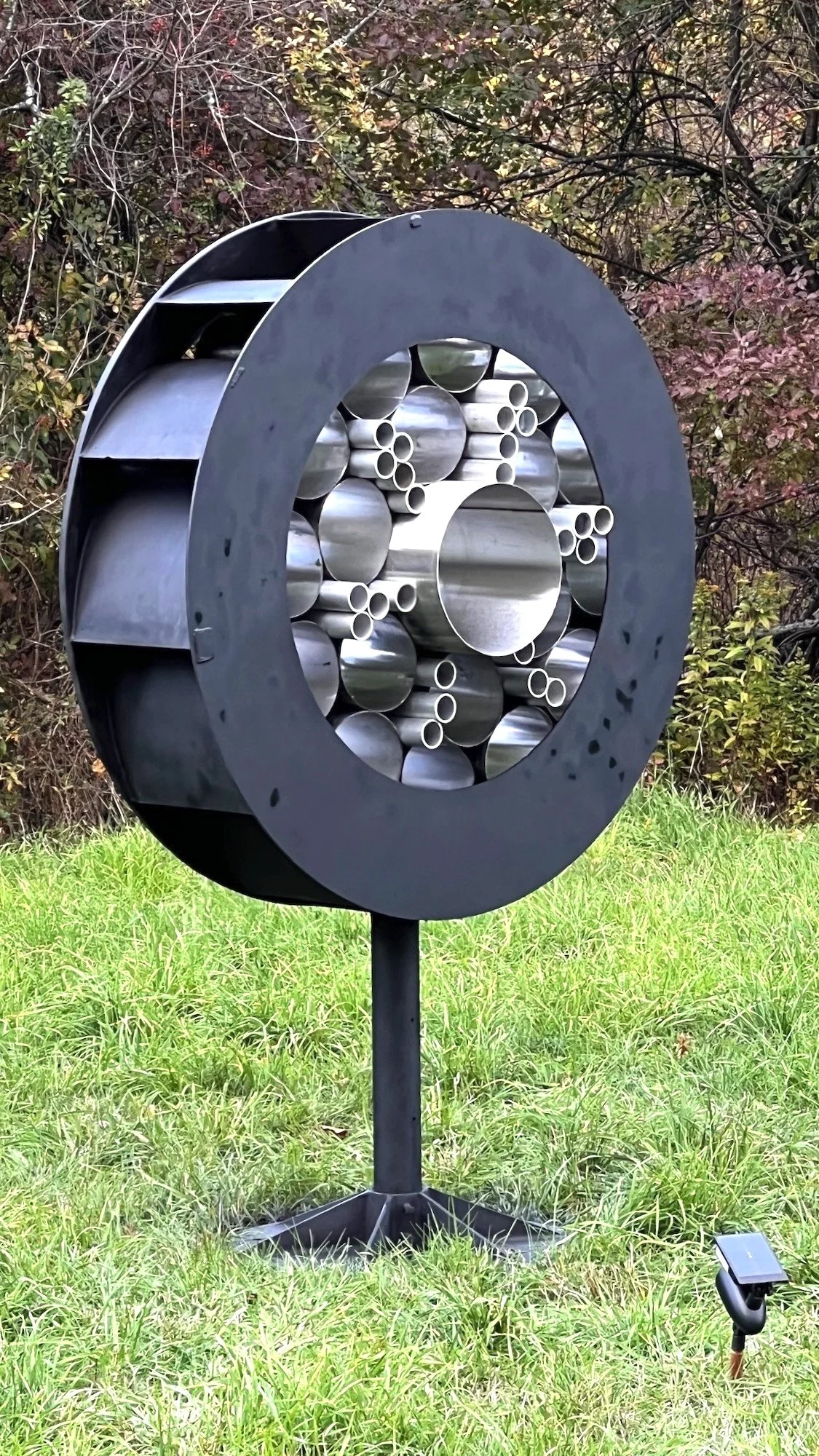 Surveillance - Inspired by the prevalence of monitoring methods that are part of our daily lives. As one drives by this piece, it appears to flicker like it’s taking a photo. Welded steel, stainless steel and aluminum cylinders. 7’5” x 5’ x 30.50”. 2