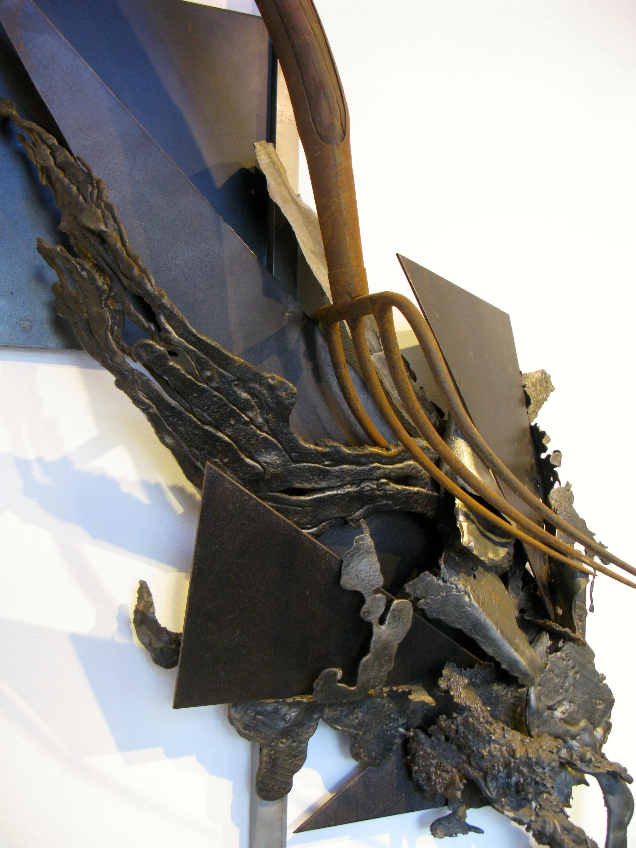 Extrusion- This work uses biomorphic forms against geometric forms to create a sense of movement. Welded steel, cast stainless steel, pitchfork. 8’7”  x 32” x  9”. 1993