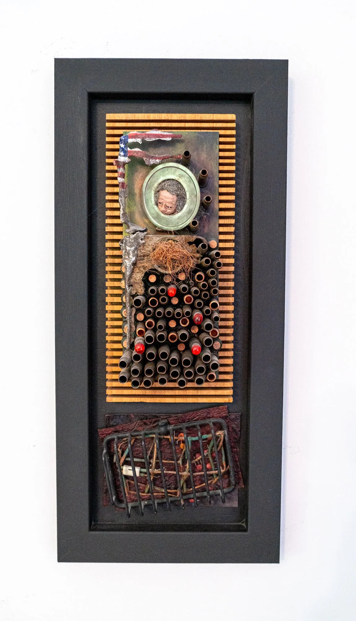 Old Glory - Inspired by those who have fought and died for the USA. Bullet casings, steel, wire, clay head, steel wool, wire basket, electrical components, gems. 22” x 10” x 4.” 2010