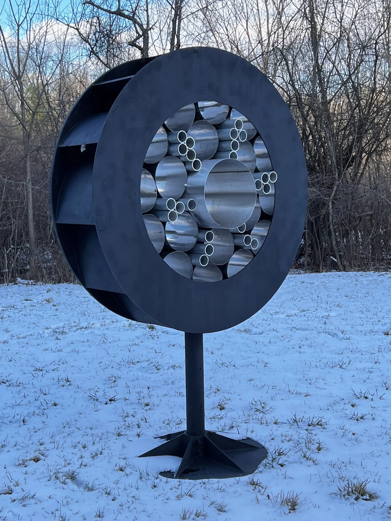 Surveillance - Inspired by the prevalence of monitoring methods that are part of our daily lives. As one drives by this piece, it appears to flicker like it’s taking a photo. Welded steel, stainless steel and aluminum cylinders. 7’5” x 5’ x 30.50”. 2