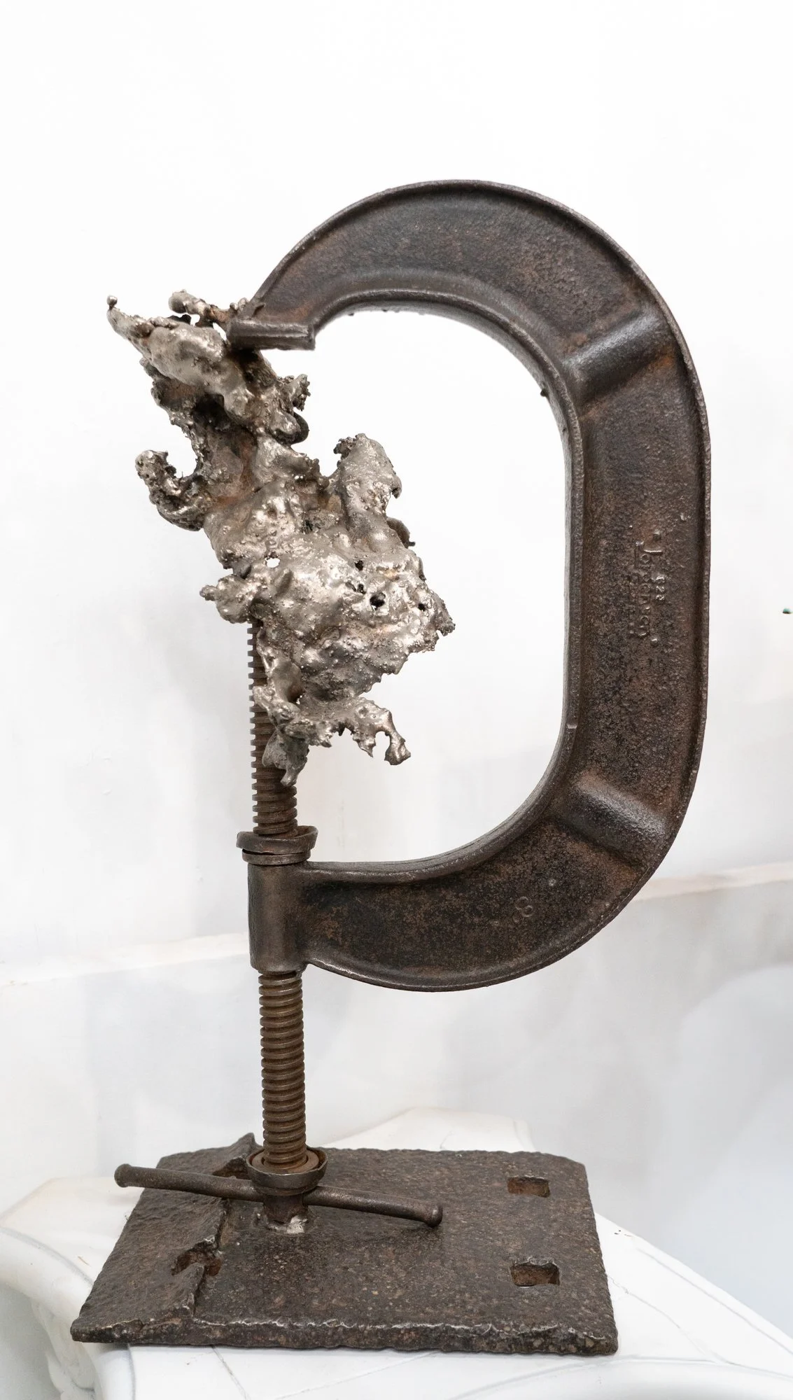 Clamped - Inspired by the scale of the vintage C-clamp. Vintage C-clamp tool, Cast stainless steel. 20” x 10.5” x 7”. 2019