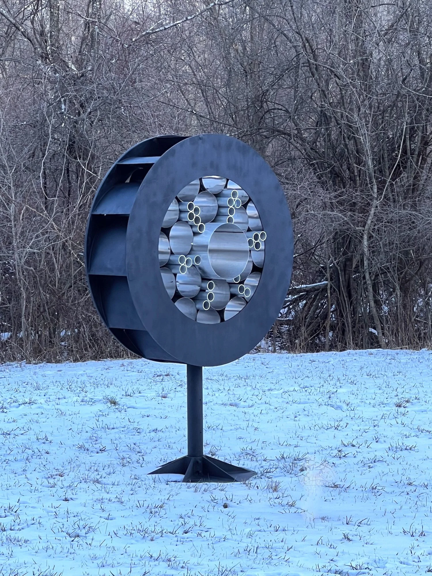 Surveillance - Inspired by the prevalence of monitoring methods that are part of our daily lives. As one drives by this piece, it appears to flicker like it’s taking a photo. Welded steel, stainless steel and aluminum cylinders. 7’5” x 5’ x 30.50”. 2