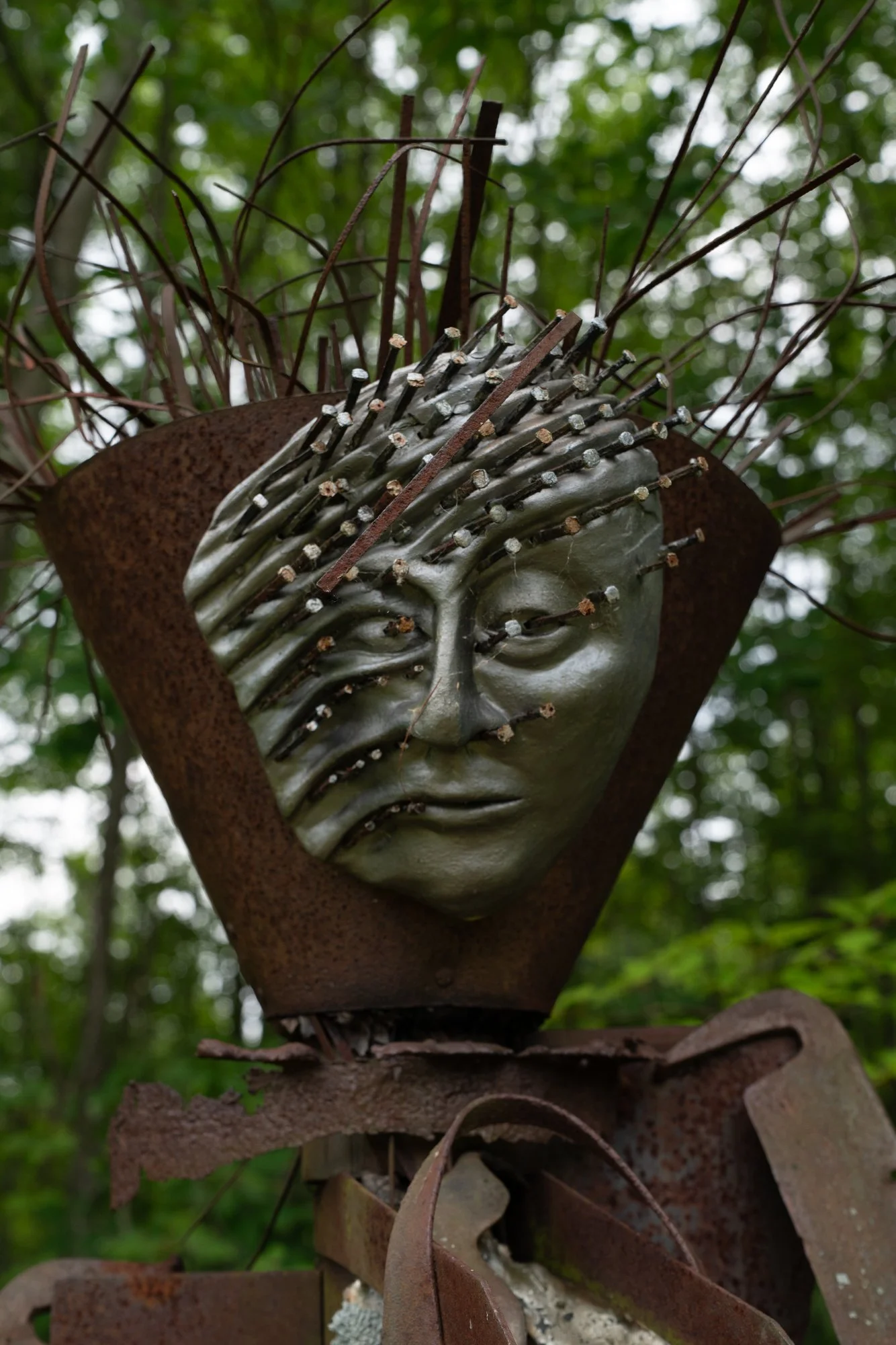 Agrarian - Inspired by the agrarian way of life in the rural upstate NY. Much of the steel in my collection has come from abandoned & outdated  farm equipment. Welded salvaged steel, modeled clay face with horse shoe nails. 8’5” x 3’ x 3’. approx. 19