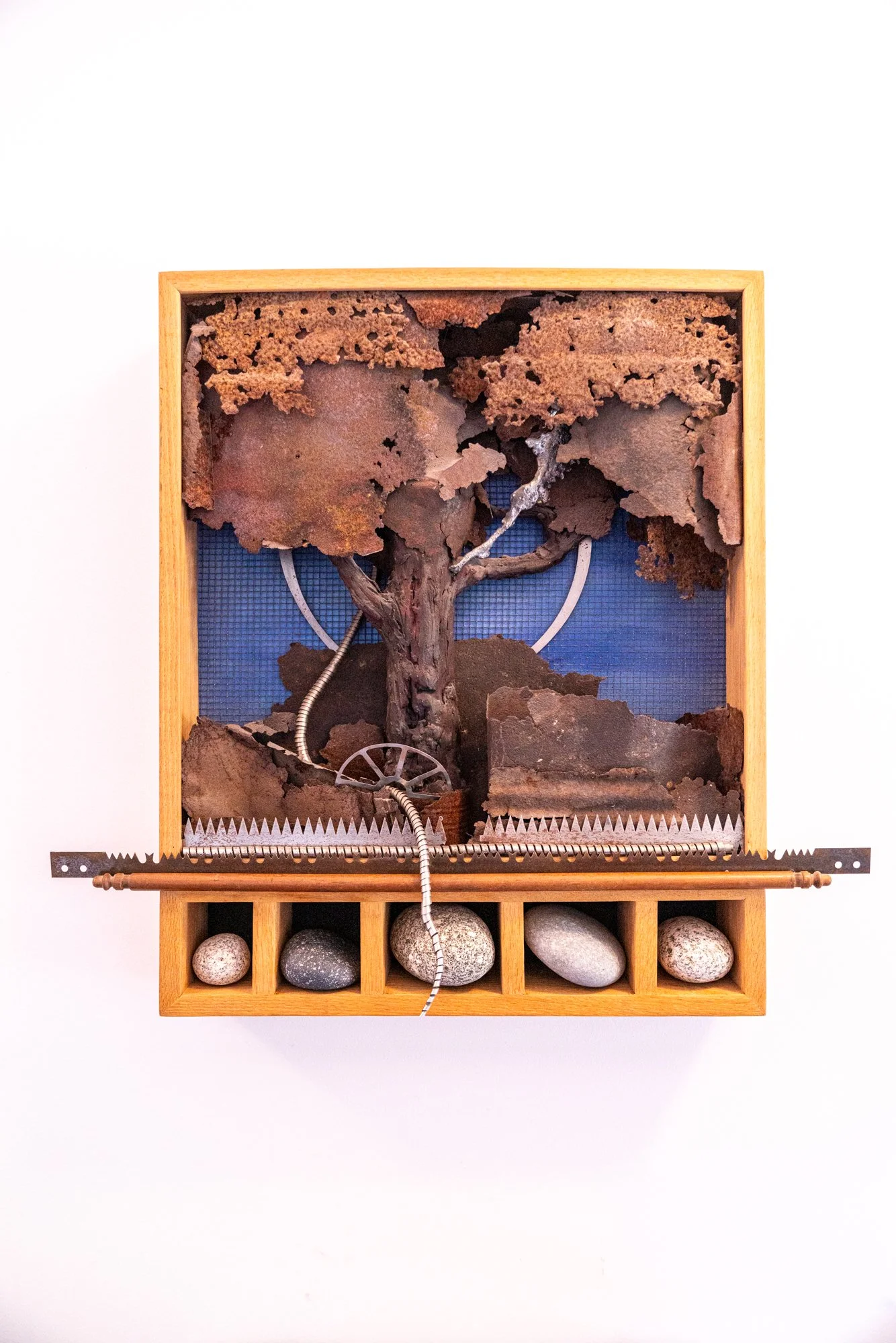 Treescape II - Inspired by nature. Clay tree, rusty steel, steel blades, cast stainless, wood, rocks. 27.25” x 30” x 5.5”. 1991