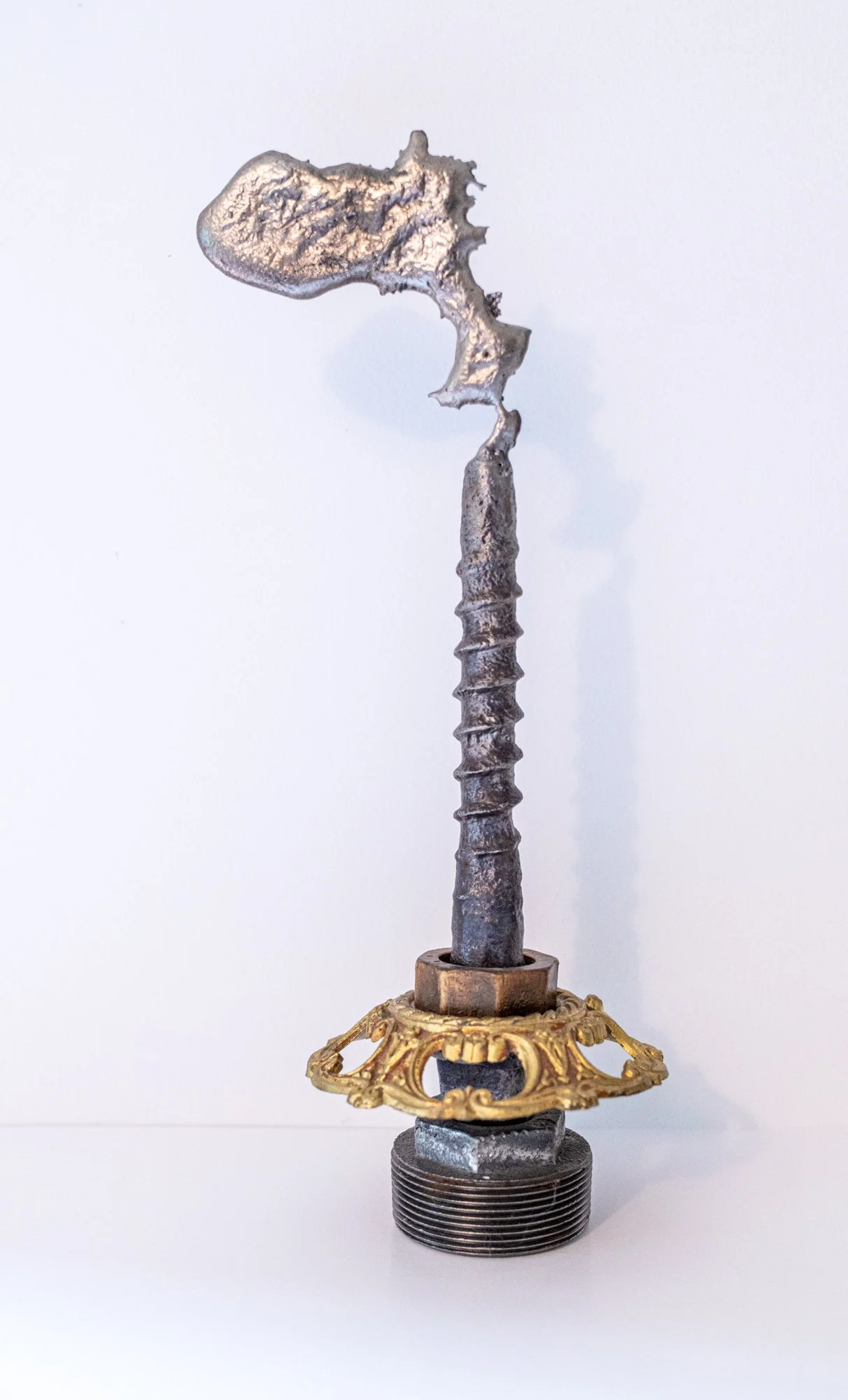 Flicker - Concept of an unsteady, wavering light / candle. Cast stainless steel, brass industrial tank cap, screw. 12.75” x 5” x 4.5” 2019