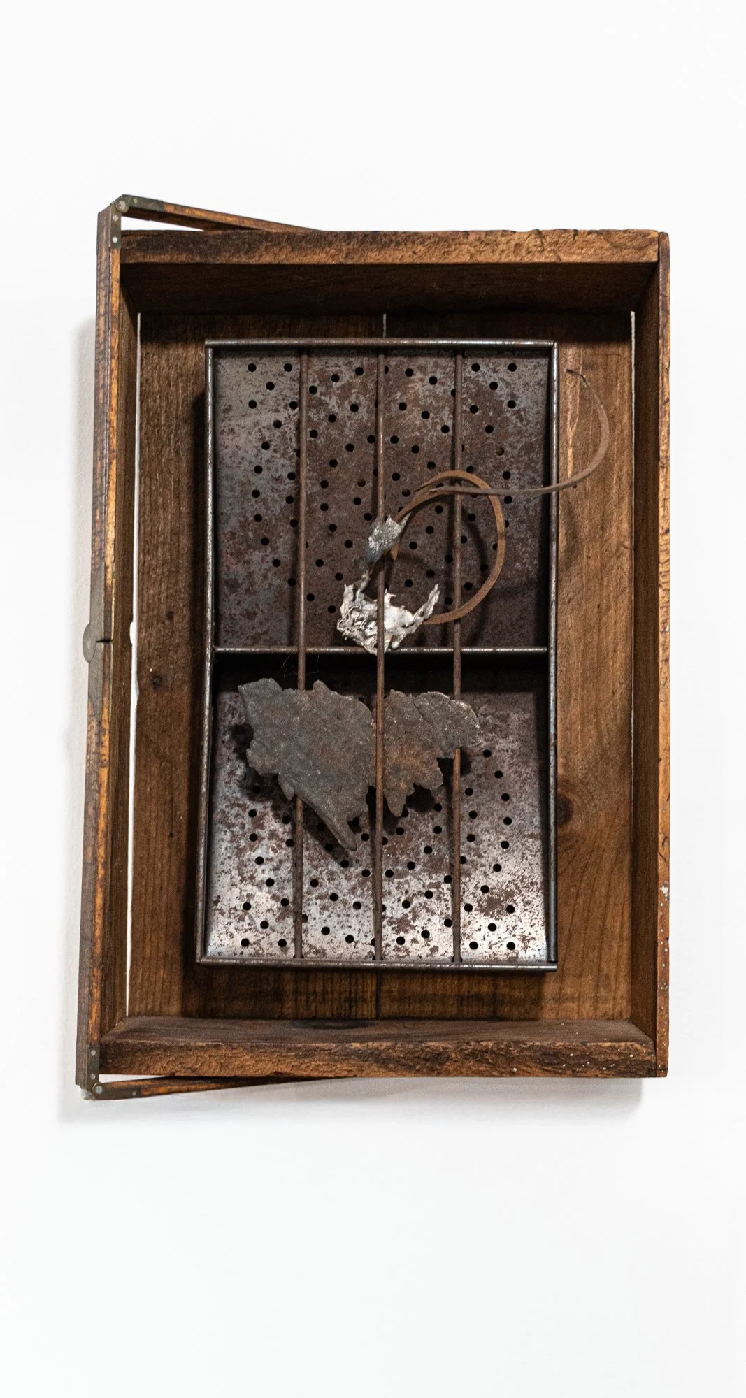Detain - Inspired by the idea of restraining or restricting freedom of movement. Vintage wooden box, metal strainer box, measuring stick, cast stainless, steel coil. 16” x 8.5” x 4.5”. 2014