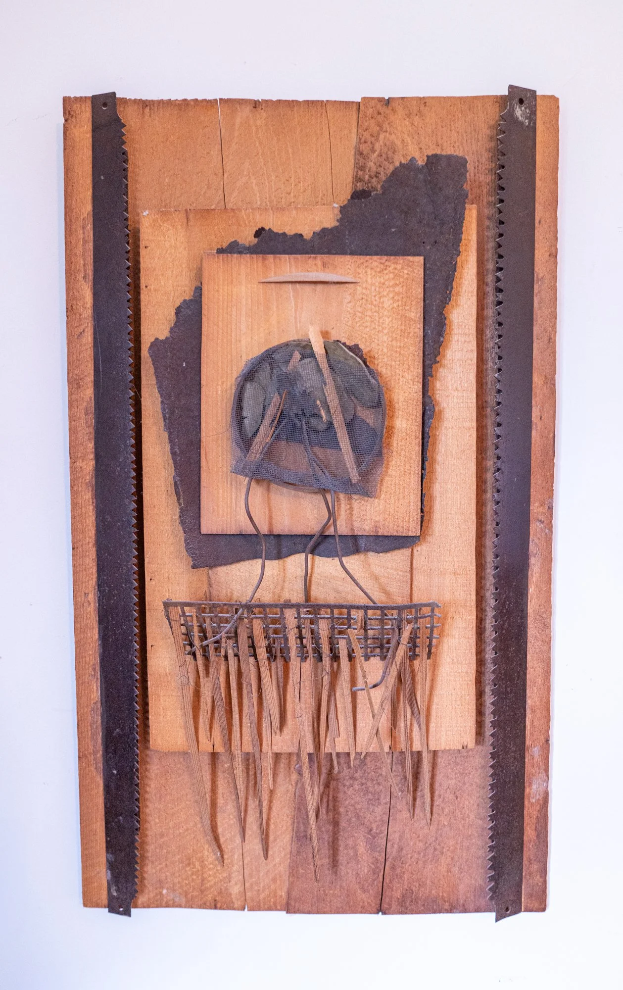 Ancestral Link - Inspired by natural elements to create a symbolic crest. Wood, stones, saw blades, steel, metal screens, rusty steel. 30’ x 17.5” x 5.5”, 1986
