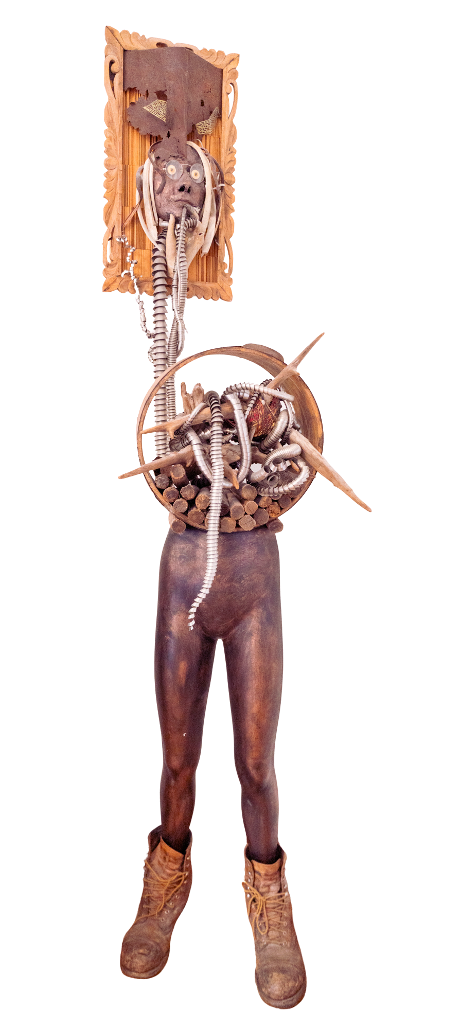 Displaced Person - Self portrait depicting a time of intense ankle pain where I attempted to “Abandon the body - rescue the brain”. Cast self portrait mask, stainless steel coils, wood spikes, drift wood, vintage wood barrel, manikin form, steel toe 