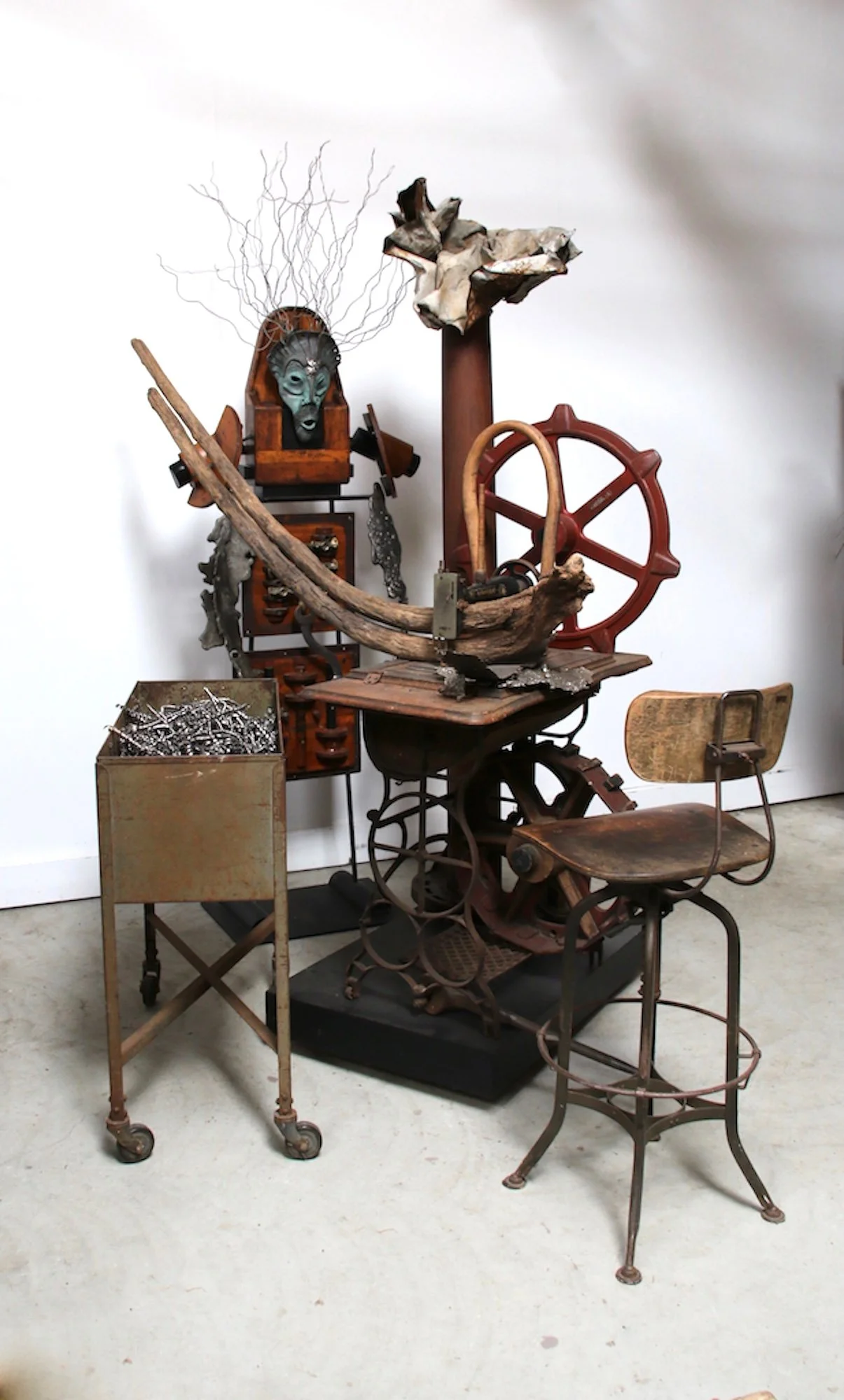 
Faith Mills - Inspired by memories of living near a knitting mill as a child. Sculpture of Shaman, vintage sewing machine, bin, stool, wood pattern pieces, metal filings, drift wood, cast stainless steel. This piece was shown at the Albany Center Ga