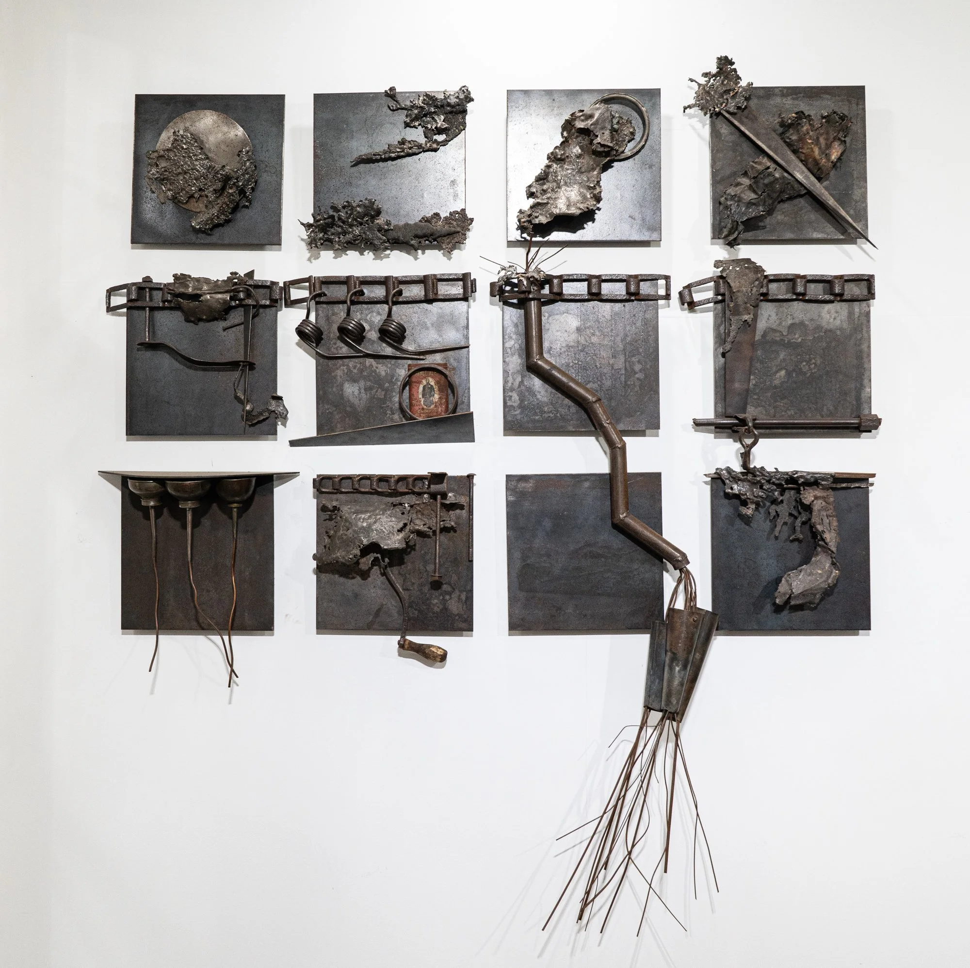 Mosaic Landscape - Inspired by man’s influence on the environment. Welded steel, cast stainless steel, oil cans, vintage tobacco can, chains. 12 - 12” x 12” panels, overall 72’ x 60’ x 10”. 1989