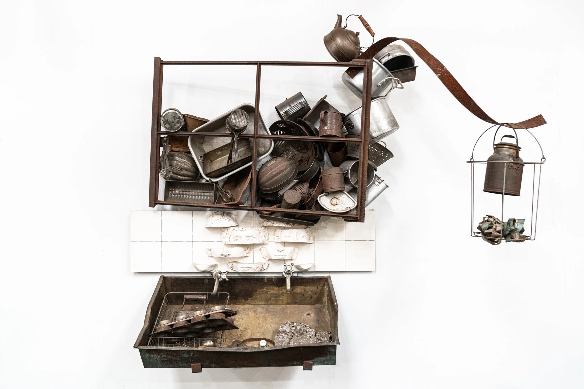Domestic Withdrawal / Multitasking - Inspired by doing required mundane tasks while dreaming to escape. This installation is still under construction. 
Vintage metal window frame, vintage pots & pans, tea kettle,  copper sink, modeled clay masks. ( M