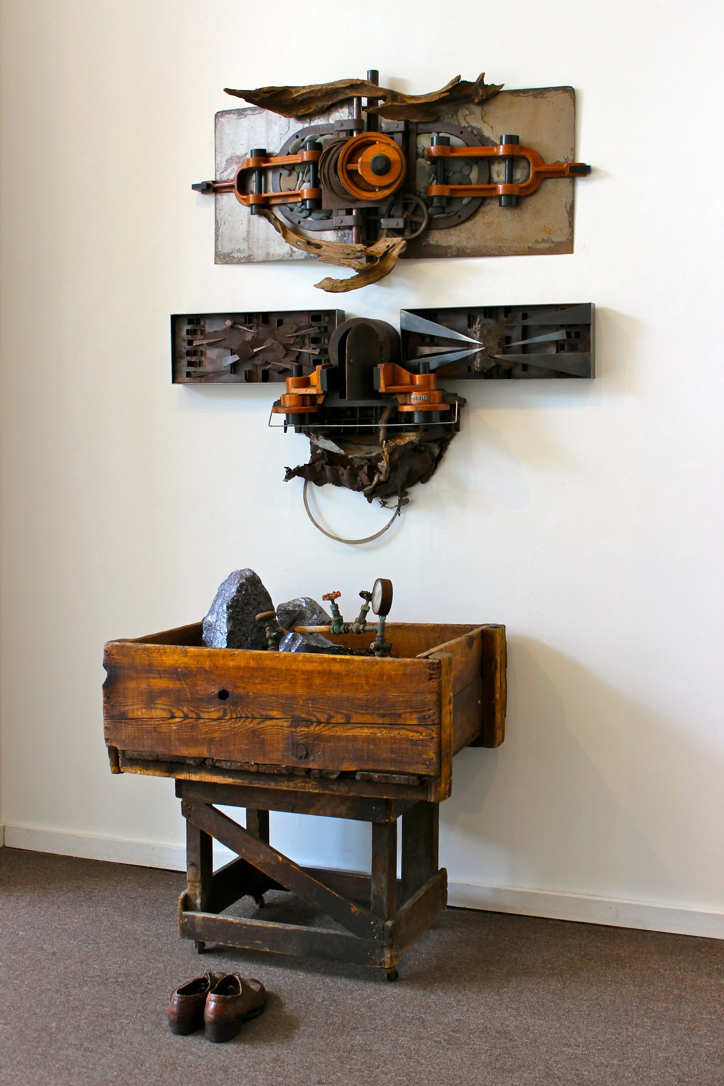 Detachment - Inspired by the fragmentation of the soul when having to continuously travel for employment. This piece was installed in the Fulton Street Gallery, Troy, NY in 2012. Wall and floor piece. Vintage wooden bin, steel filings, shoes, 4 wall 