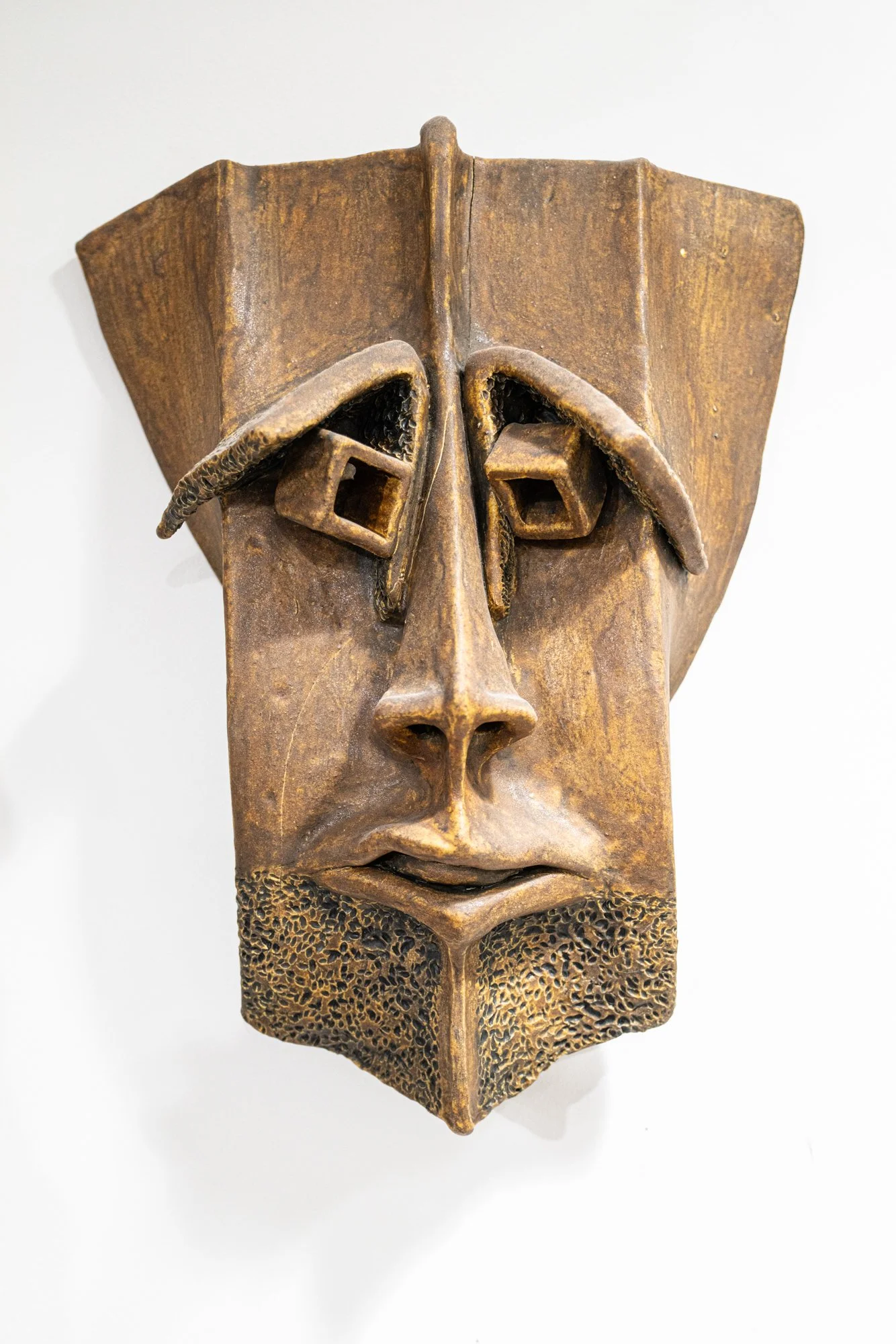Extruded Mask - Extruded modeled clay. Low fire clay, rust glaze. 18’ x 12” x 5” 
