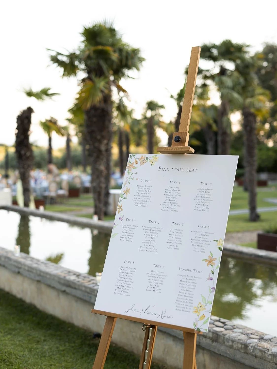 Wedding seating chart on easel outdoors with palm trees