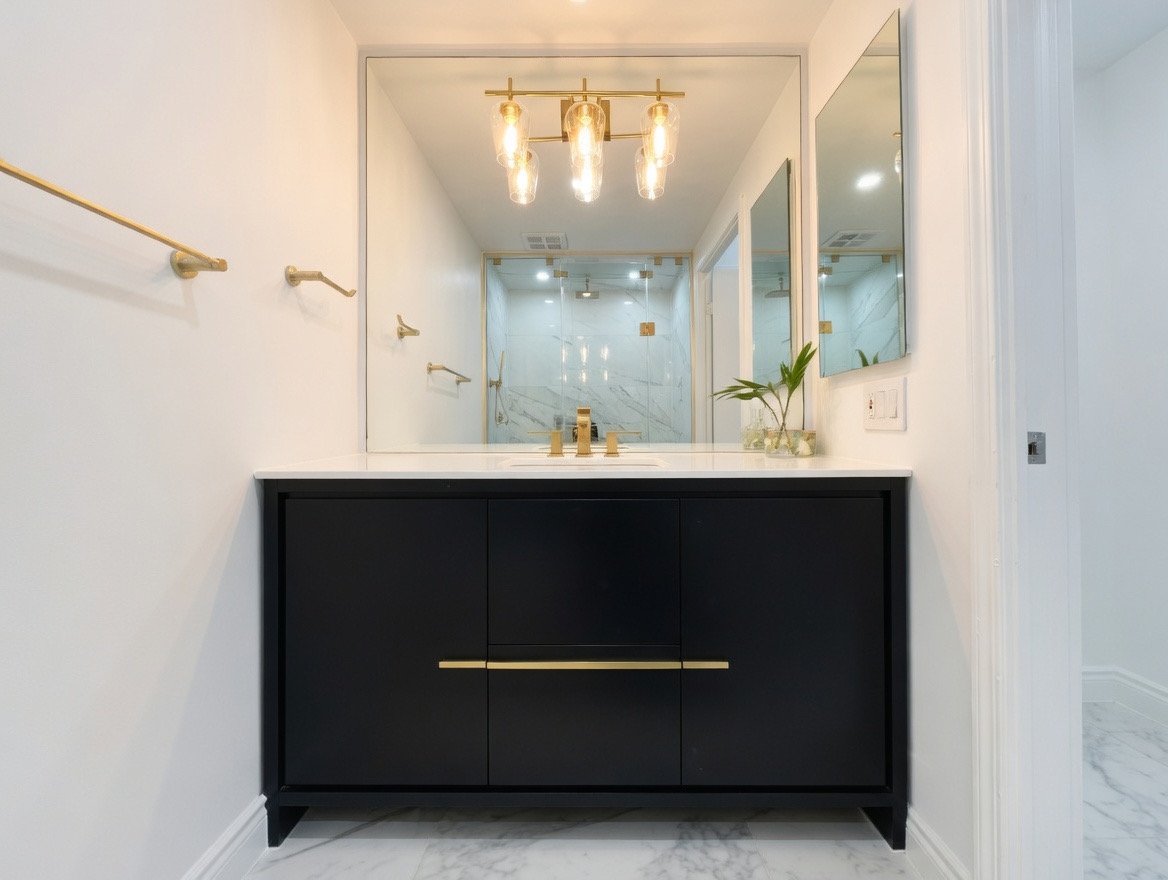 after picture of the new vanity and gold faucets. gold towel bars and vanity light