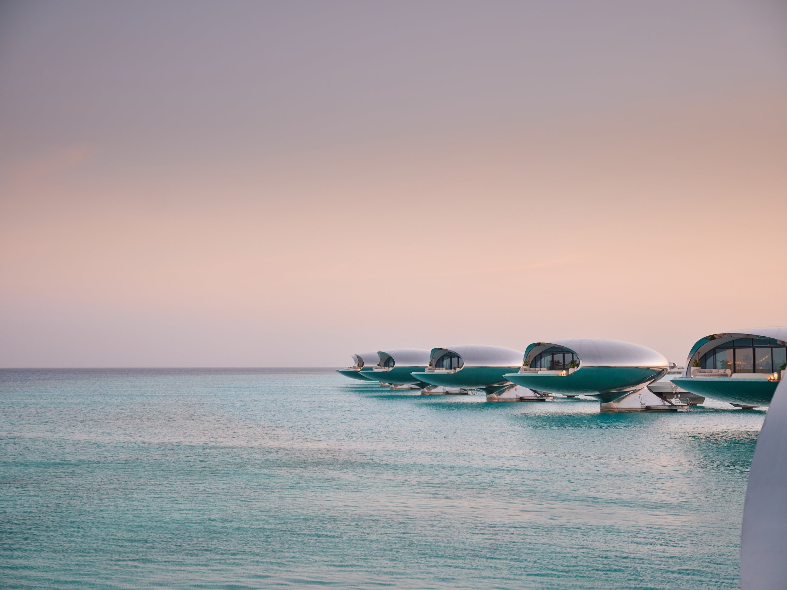 Futuristic floating hotel pods on calm ocean water at sunset or sunrise