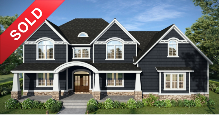 Two-story dark gray house with white trim, a front porch, and multiple large windows, surrounded by green landscaping and trees, with a blue sky background. A red "SOLD" banner overlays the top left corner.