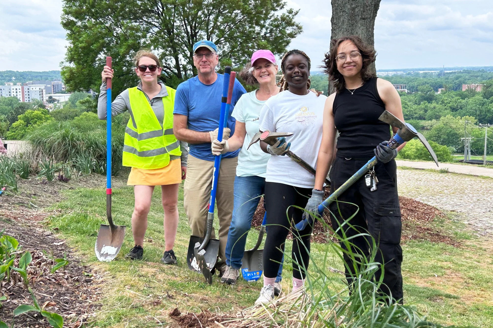 Volunteers posing for a photo holding gardening tools at Libby Hill Park's community mulch day