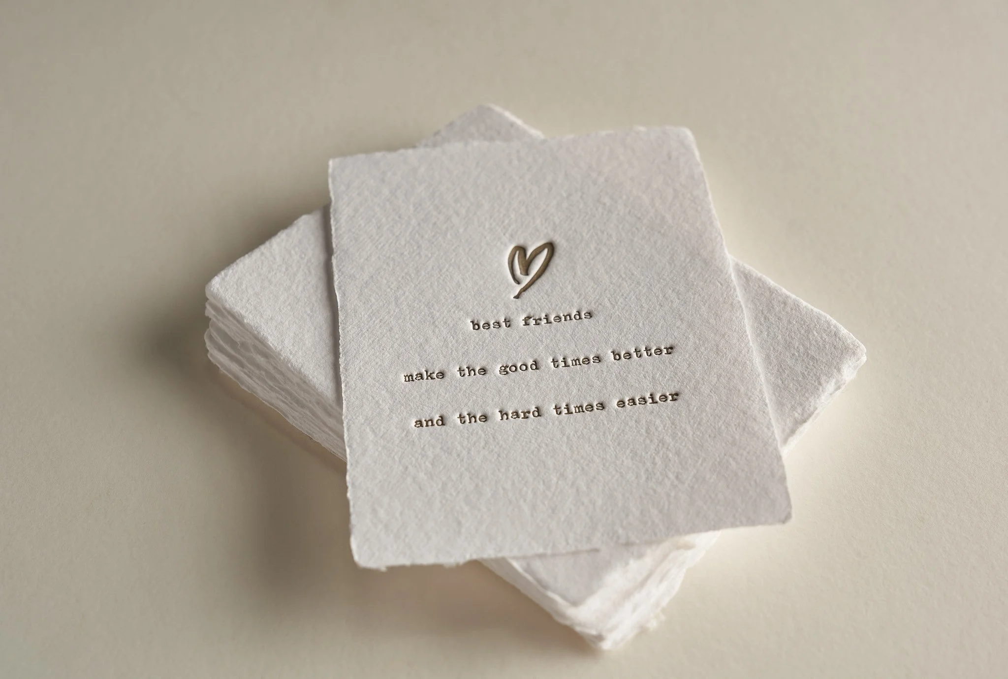 Stack of white paper napkins with a small handwritten heart and text that reads "best friends make the good times better and the hard times easier".