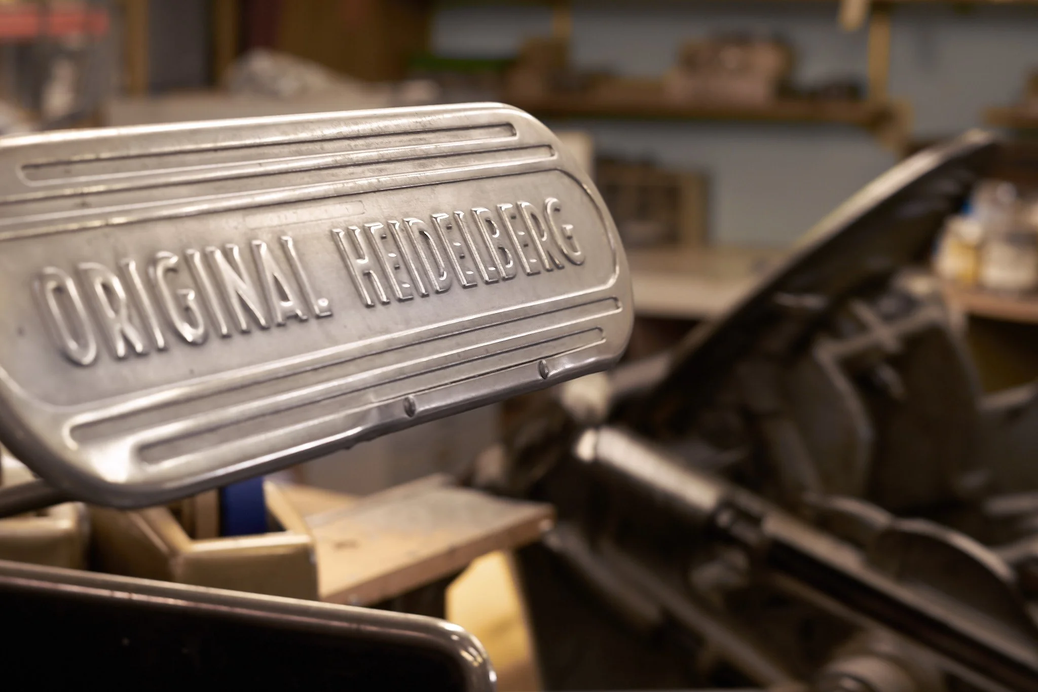 Close-up of a vintage footboard with the brand name embossed, situated in a workshop setting.