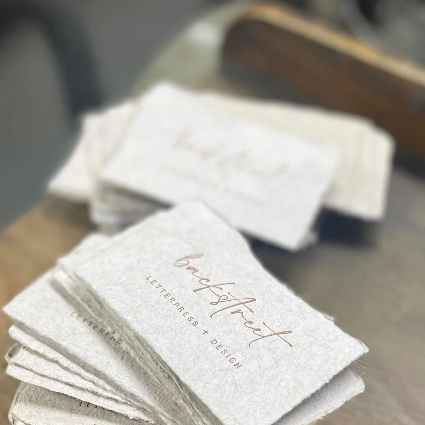 Stack of textured paper cards with the words 'handmade,' 'letterpress,' and 'design' printed on them.