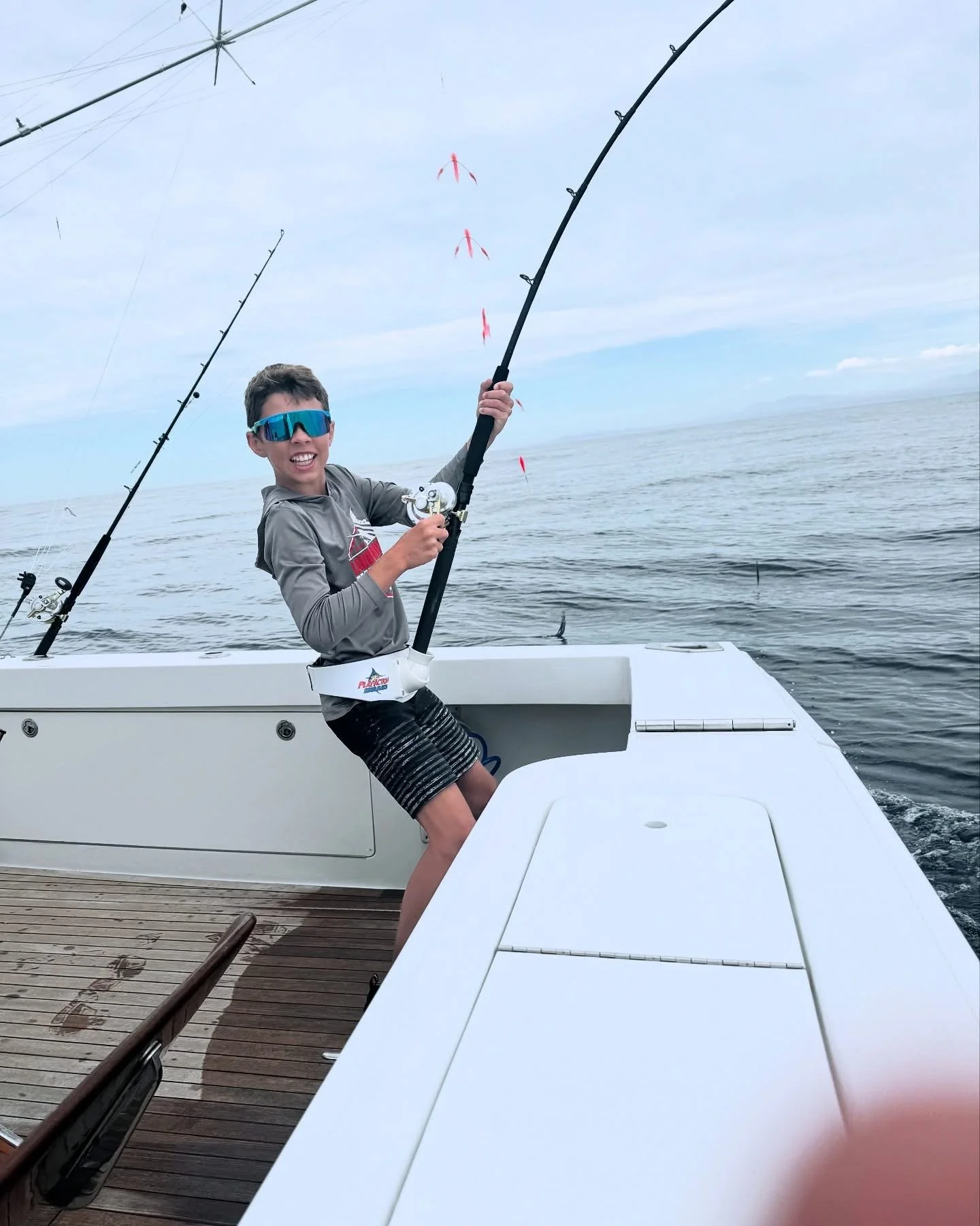 Young fisherman hooked up to a marlin and having a great time fishing in Cabo