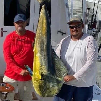Captain and mate show off big dorado caught deep sea fishing in Cabo