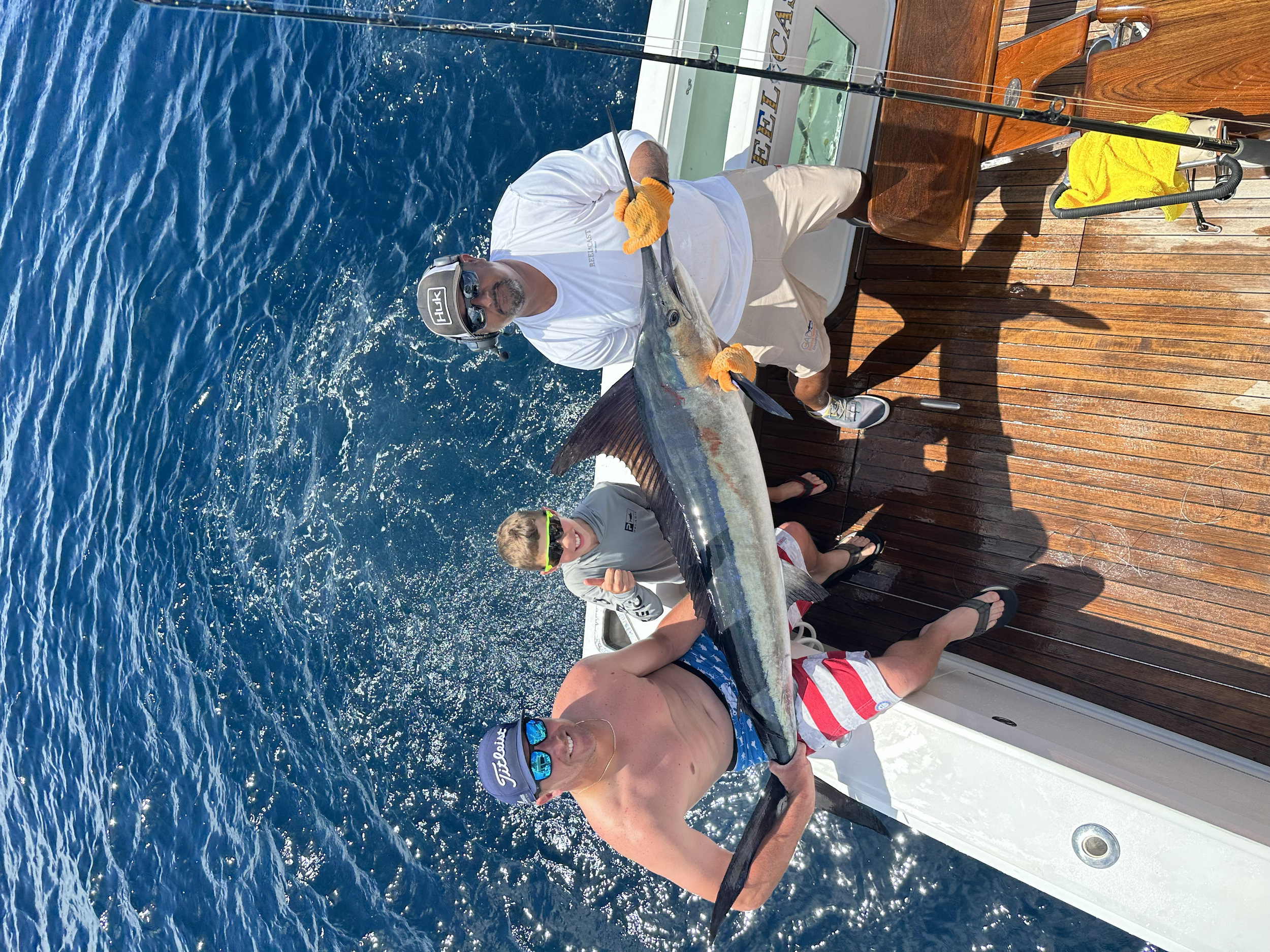 Young anglers showing off their marlin catch while deep sea fishing in Cabo