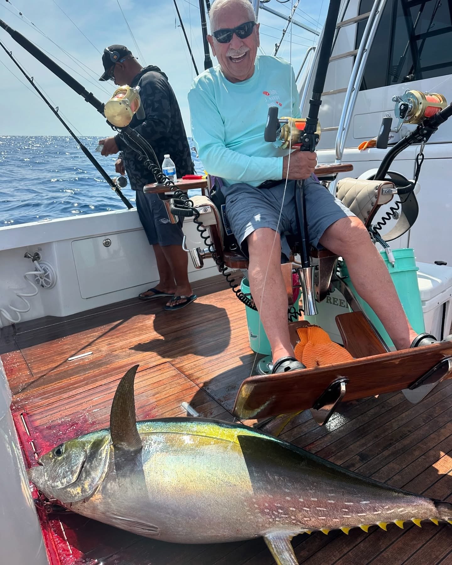Angler in the fighting chair with a big smile after catching a nice yellowfin tuna offshore in Cabo