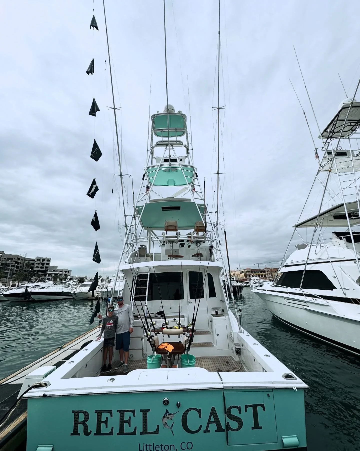 Father and son flying marlin release flags flying after a successful day fishing offshore in Cabo