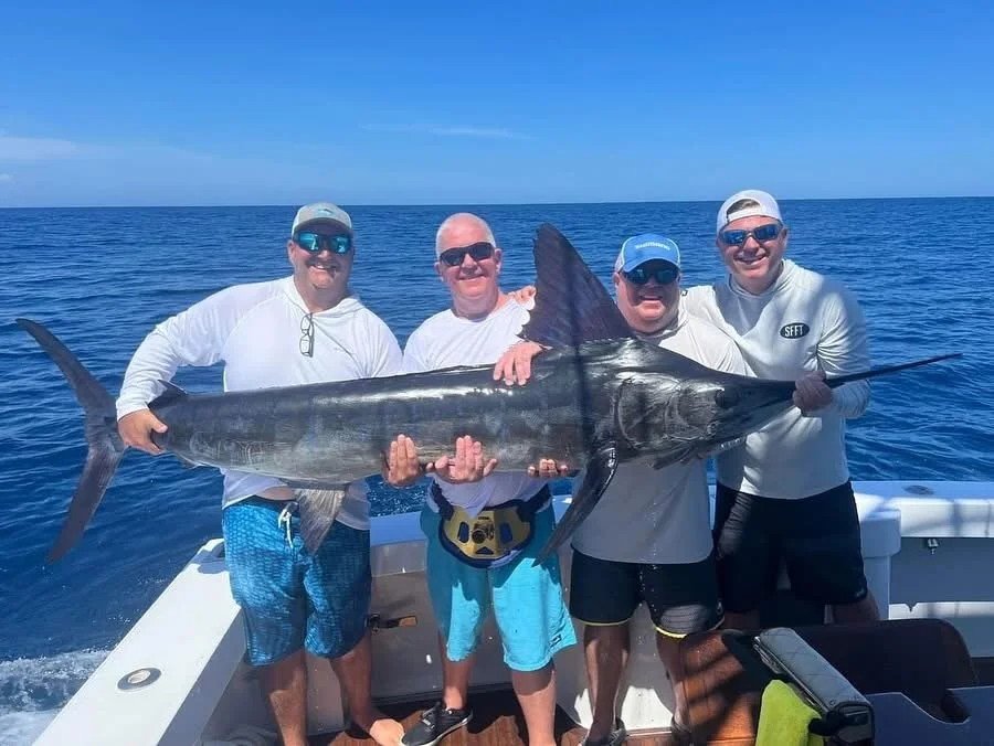 Group of anglers showing off marlin caught while fishing offshore in Cabo