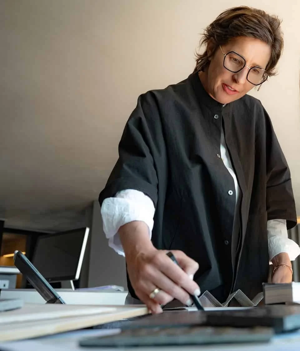 Architektin Angelika Mair zeichnet auf einem Zeichenbrett auf einem Tisch.