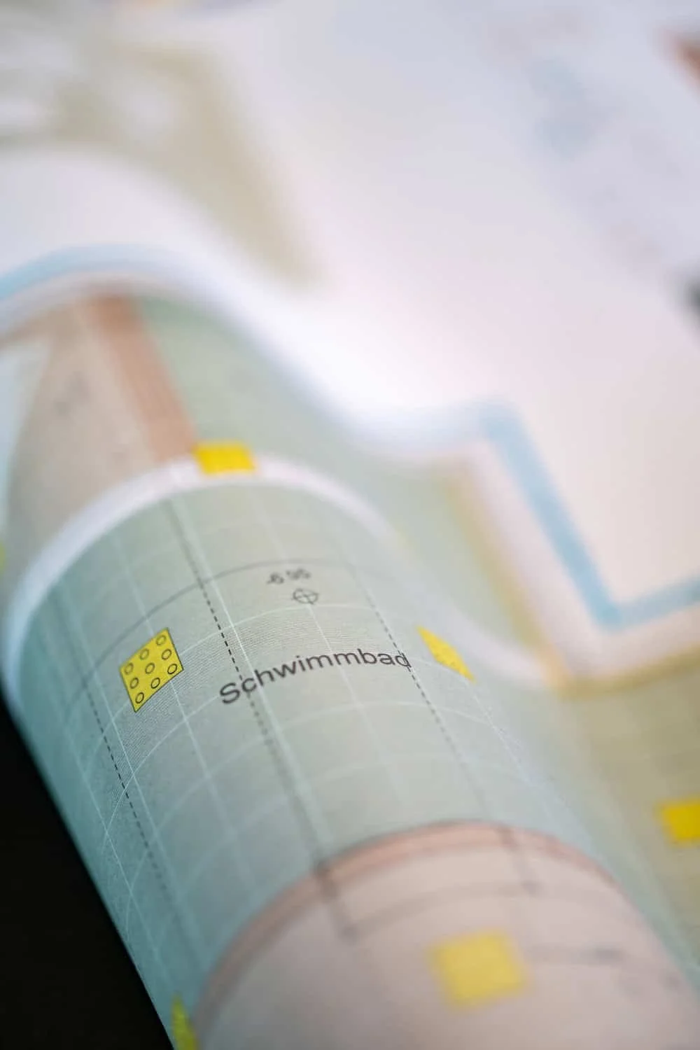 A close-up of a printed city map, with the word 'Schwimmbad' visible, indicating a swimming pool location.