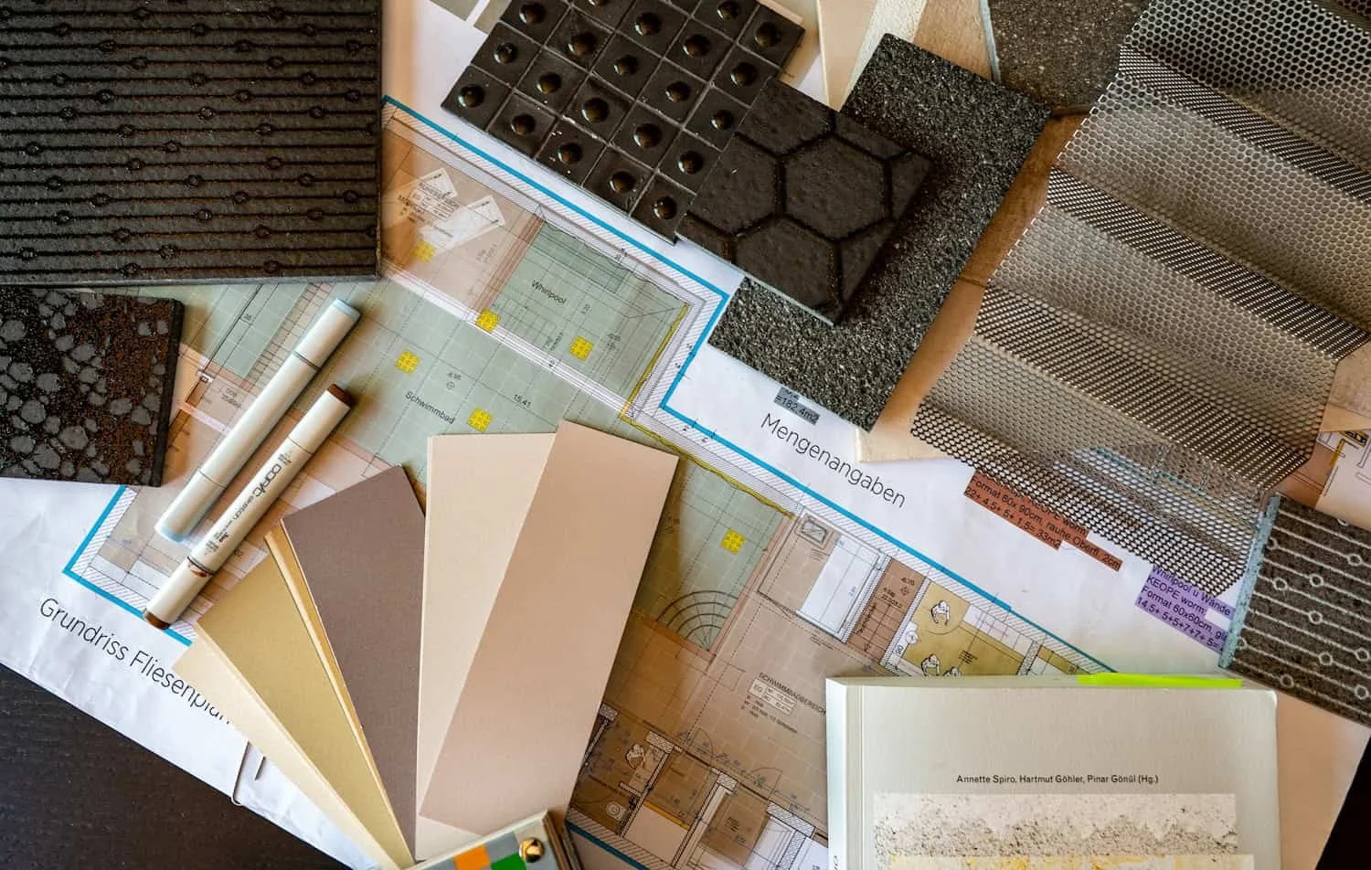 Bodenbeläge und Materialien für einen Bodenbelag wie Fliesen, Keramik, Gummi, Metall und Steine, sowie Baupläne, Farbfächer und Markierstifte.