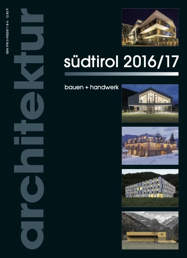Titelbild eines Architektenatlas mit dem Titel "südtirol 2016/17" und dem Untertitel "bauen + handwerk". Das Bild zeigt fünf verschiedene moderne Gebäude: ein hell erleuchtetes mehrstöckiges Gebäude bei Nacht, ein Holzhaus bei Nacht, ein mehrstöckiges Holzgebäude im Schnee, ein kubisches Gebäude mit quadratischen Fenstern in einer ländlichen Umgebung, und eine lange, gelbe, schlichte Bauform in einer bergigen Landschaft.