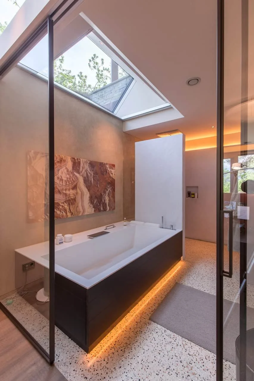 Modernes Badezimmer mit freistehender Badewanne, Oberlichter und indirekter Beleuchtung.