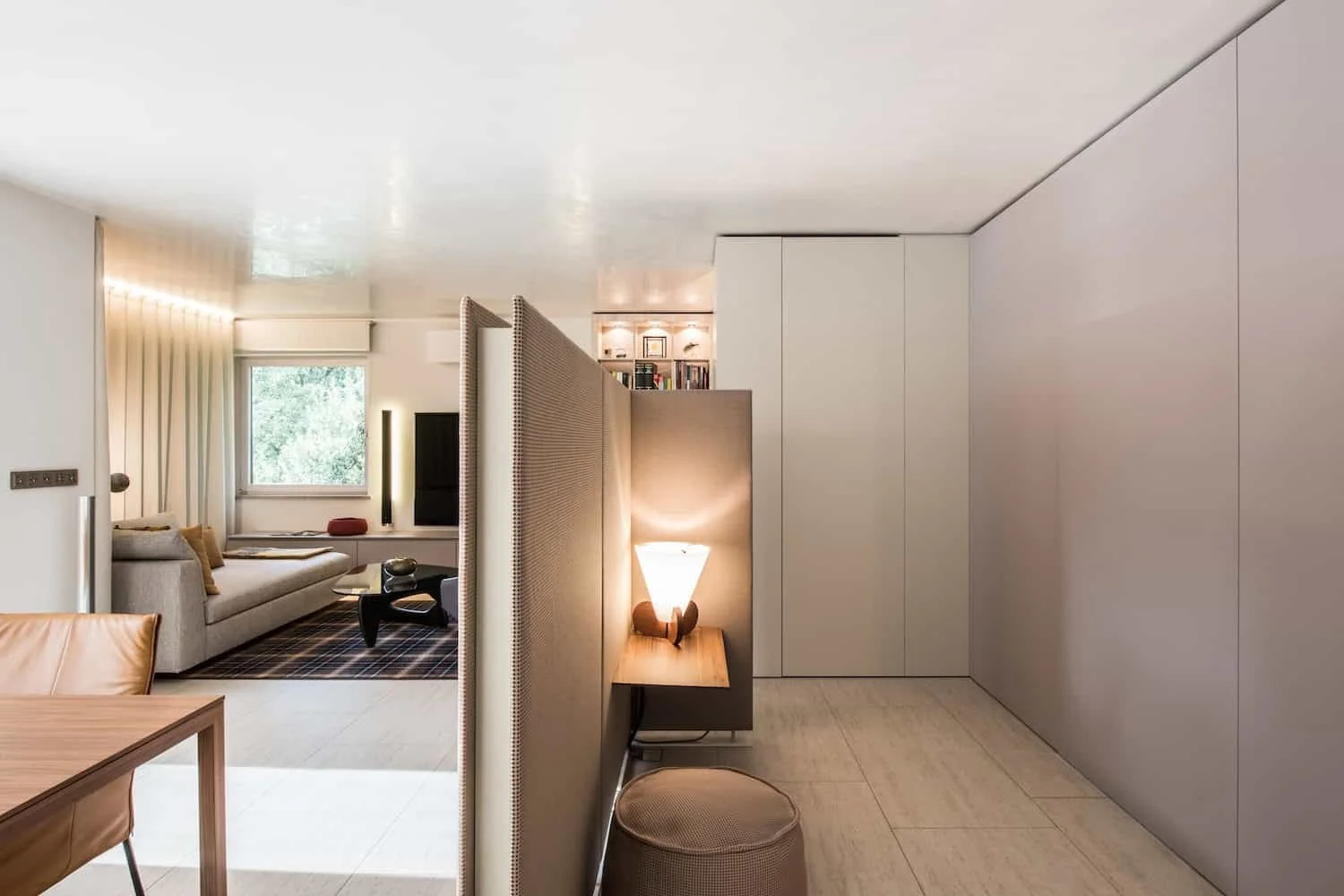 Modernes Wohnzimmer mit Sofa, Fernseher, Fenster, Teppich und viel natürlichem Licht.