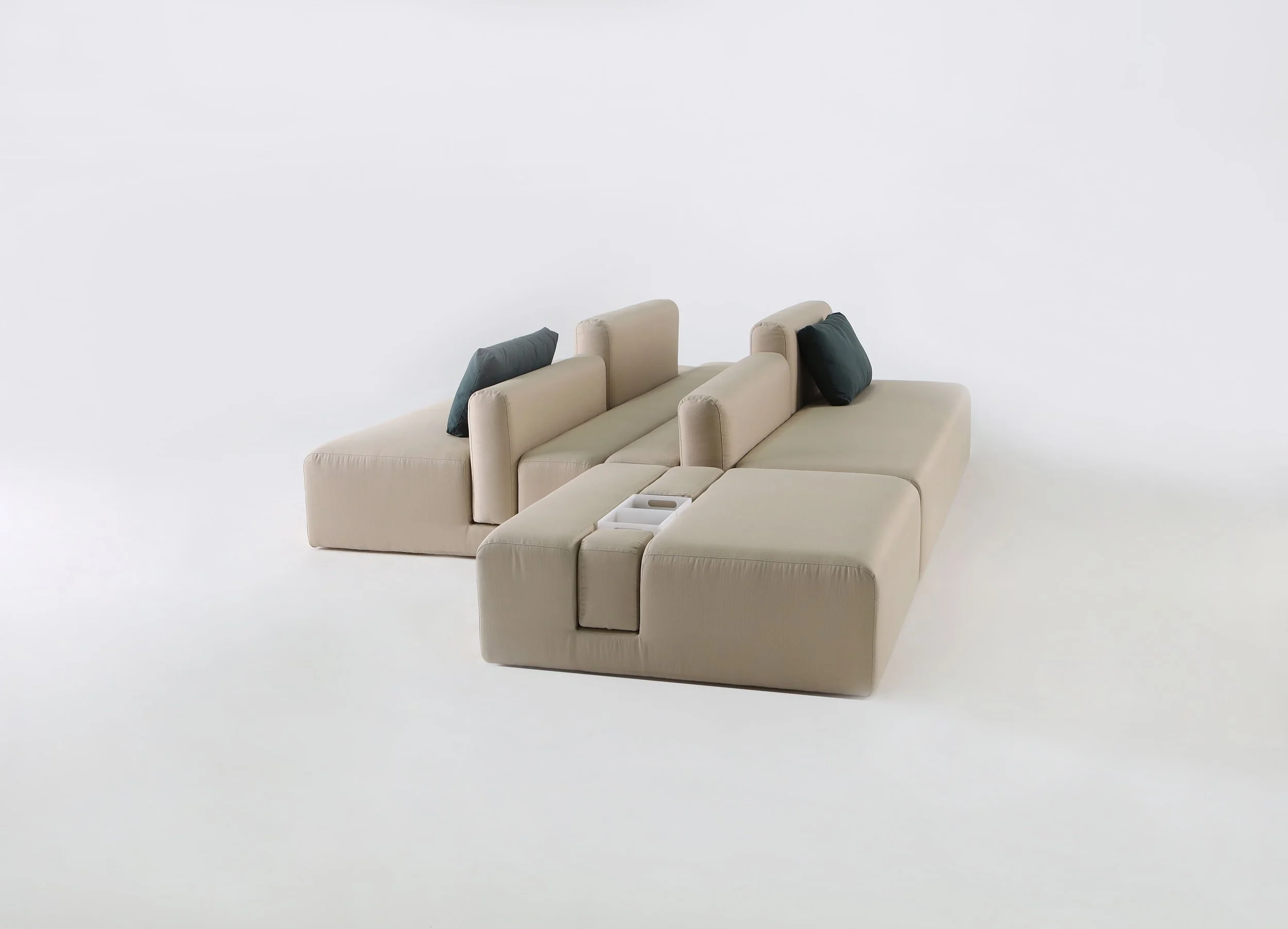 Modern beige sectional sofa with black accent pillows against a white background.