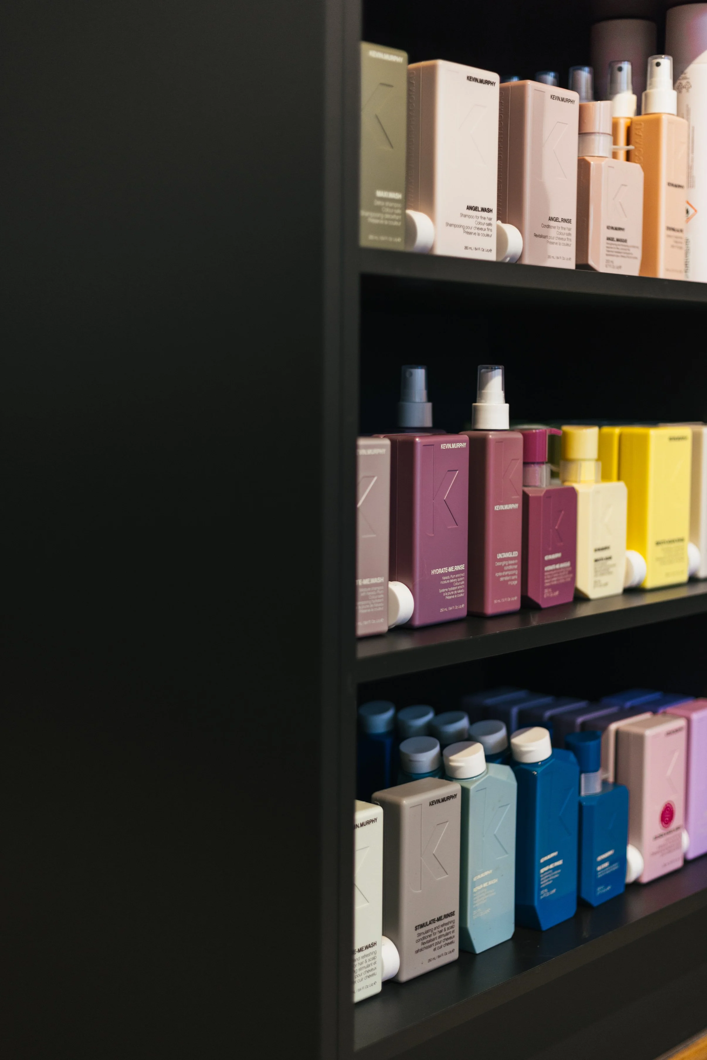 Regale mit Flaschen und Verpackungen von Kevin Murphy Haarpflegeprodukten in verschiedenen Farben.