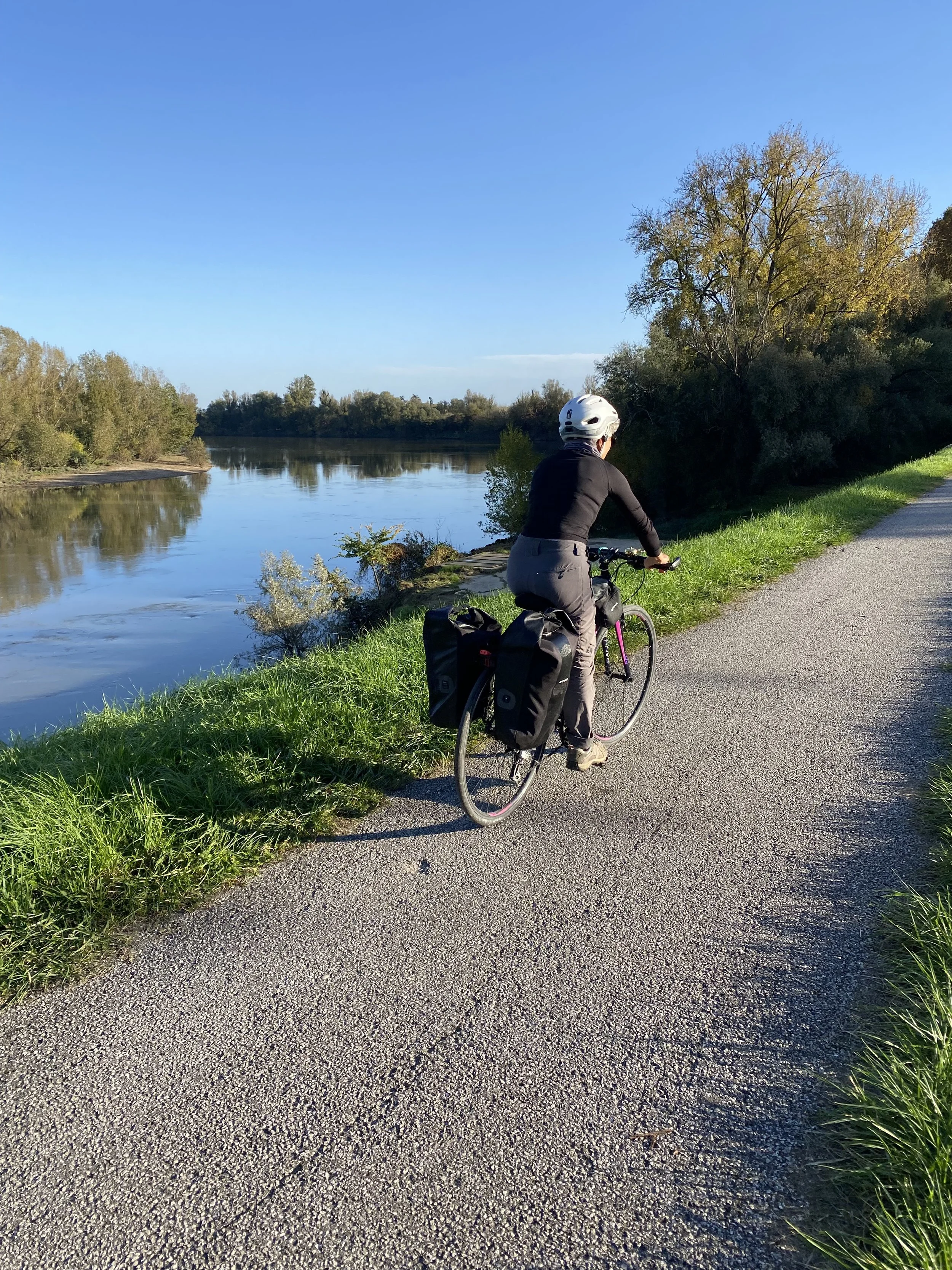 Une personne fait du vélo le long d'une rivière sur la Scandibérique.