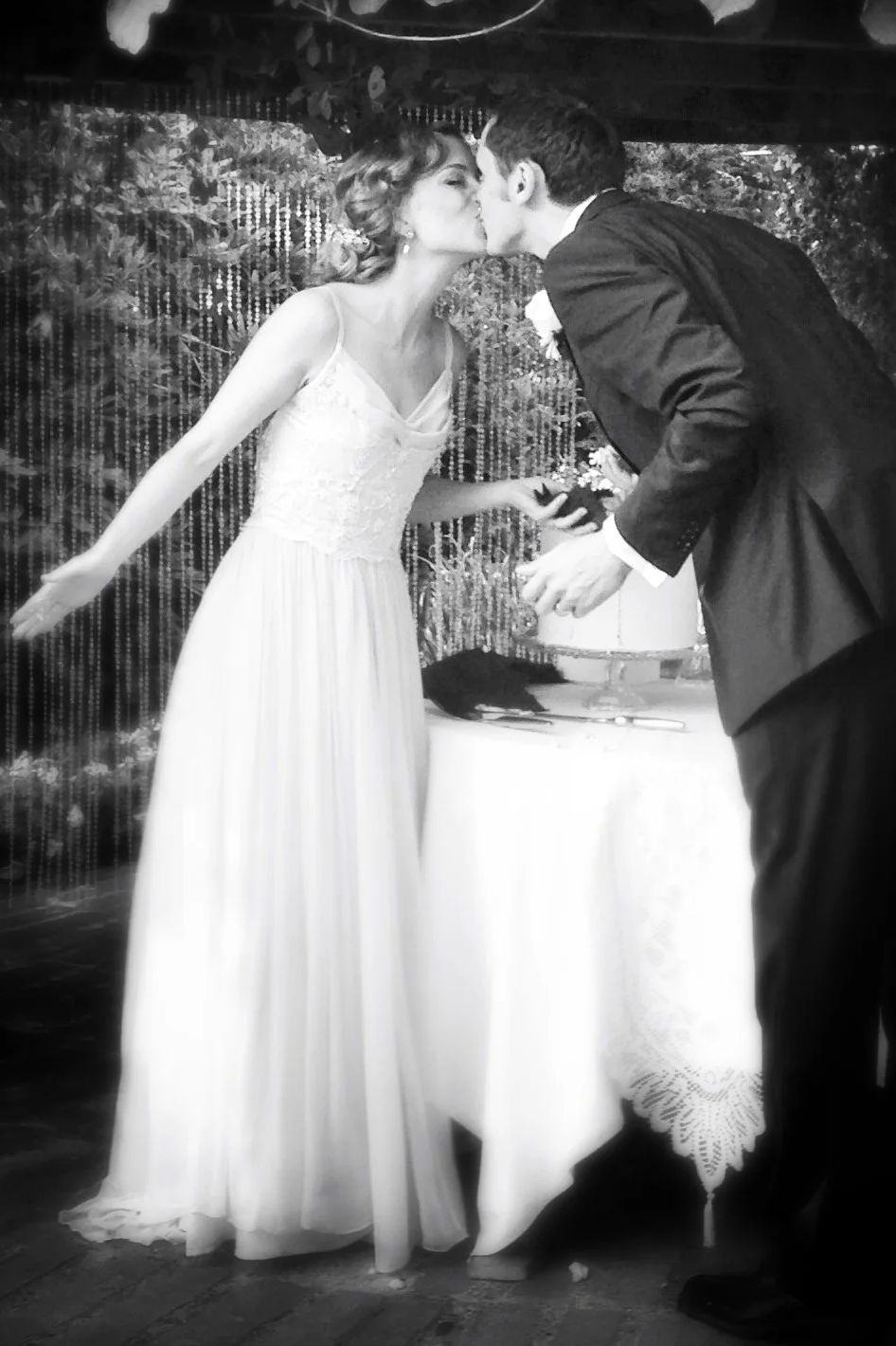 Black and white photo of bride and groom sharing an intimate kiss during their wedding day