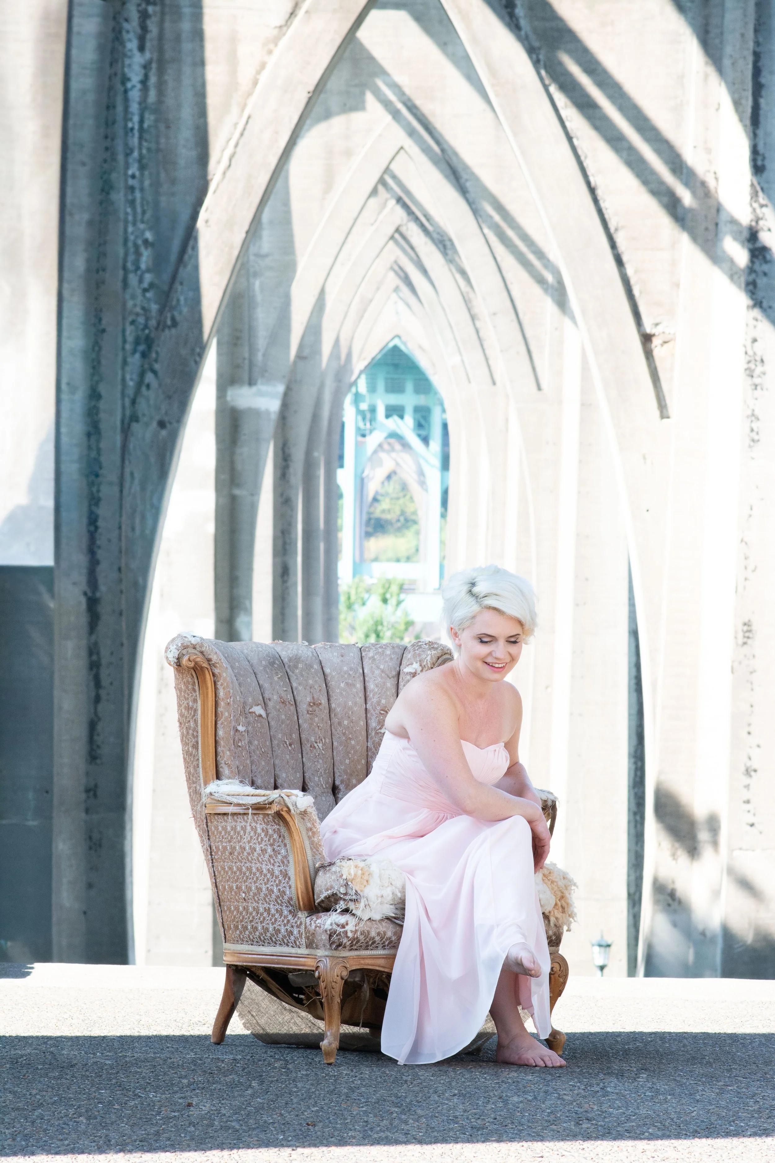 Seattle wedding photographer bride in soft blush gown seated under light filled arches portrait Tacoma wedding photographer