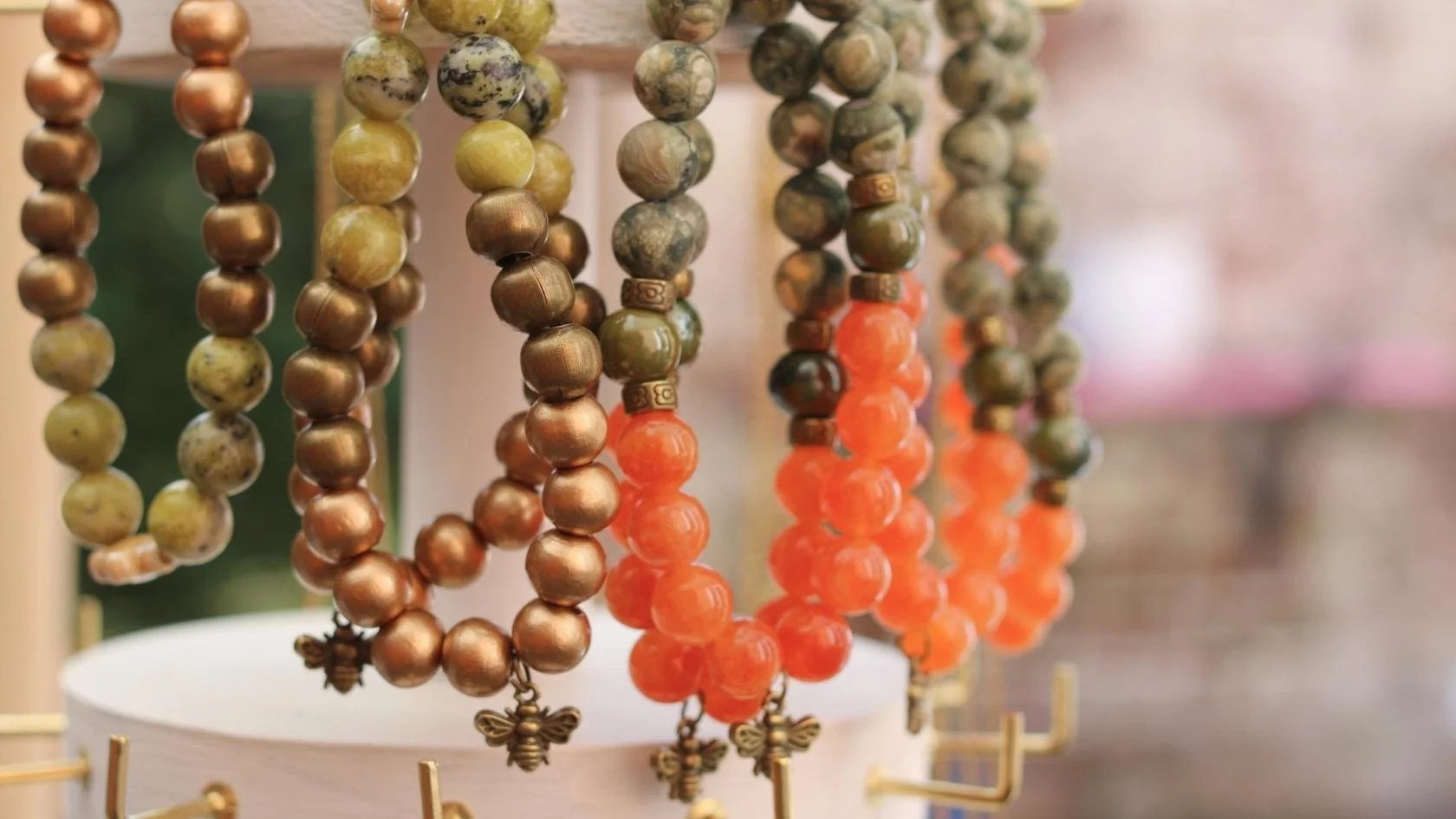 Close-up of several beaded necklaces hanging on display.