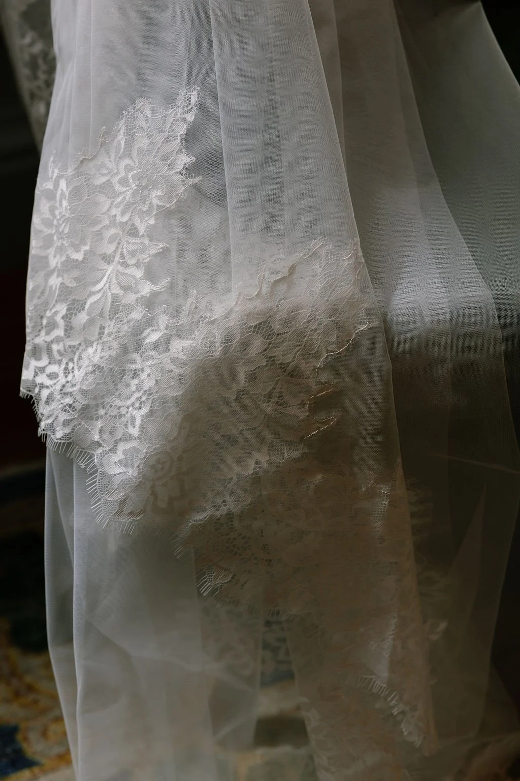 Close-up of white bridal veil with lace embroidery detail.