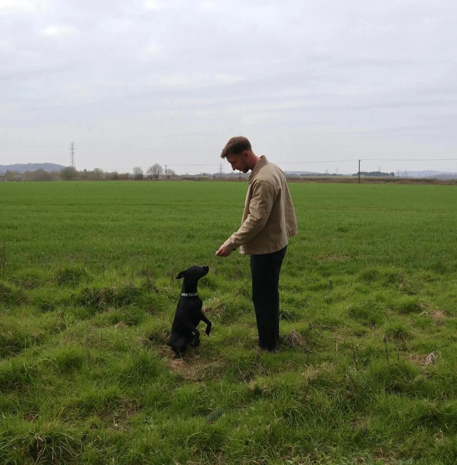 Kal from Roamwild Studio with a dog in a countryside field