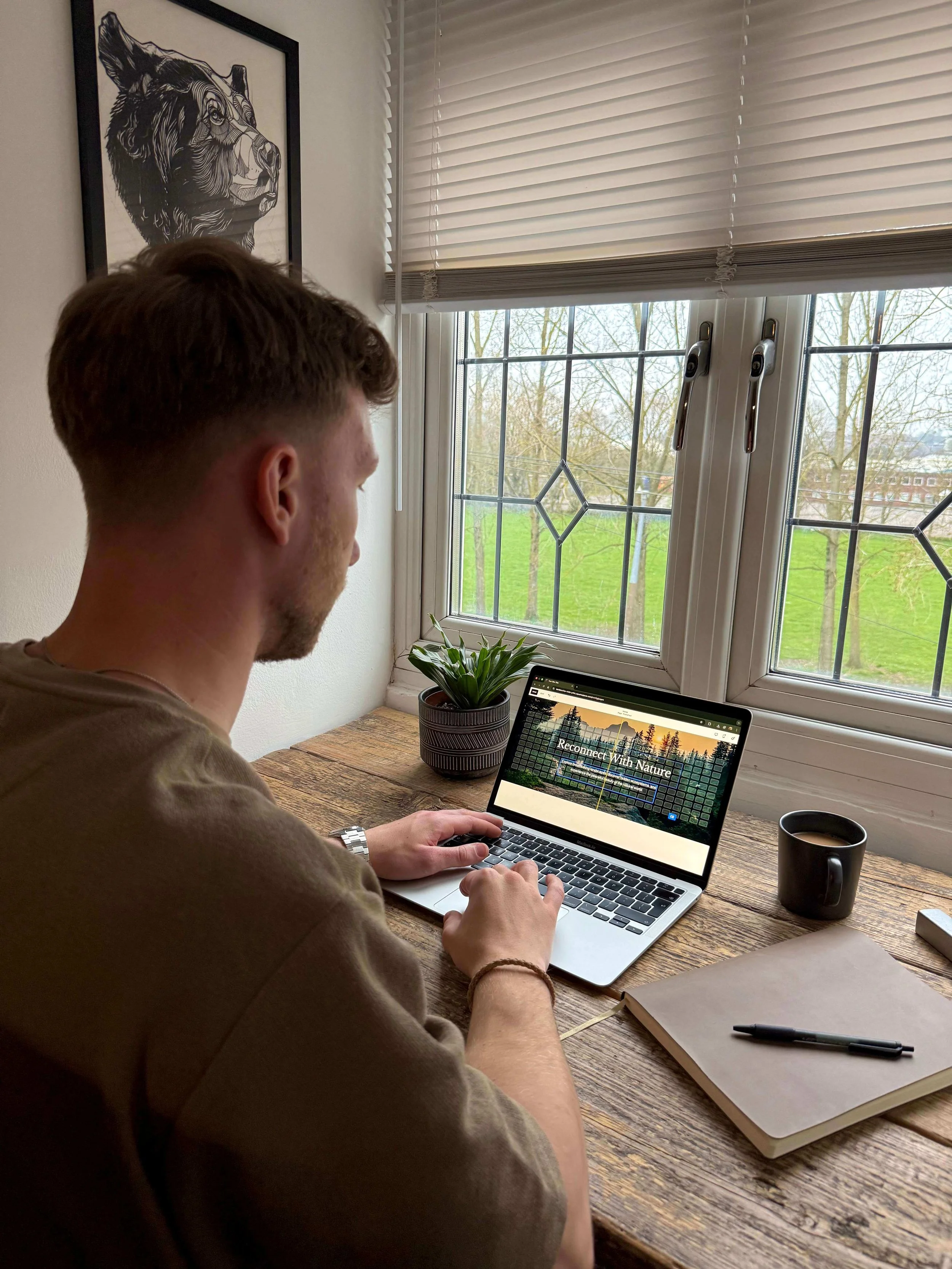 Kal from Roamwild Studio designing a nature-inspired website on a laptop