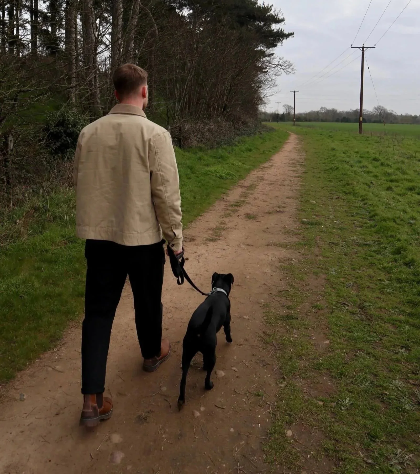 Kal from Roamwild Studio walking a dog on a countryside path